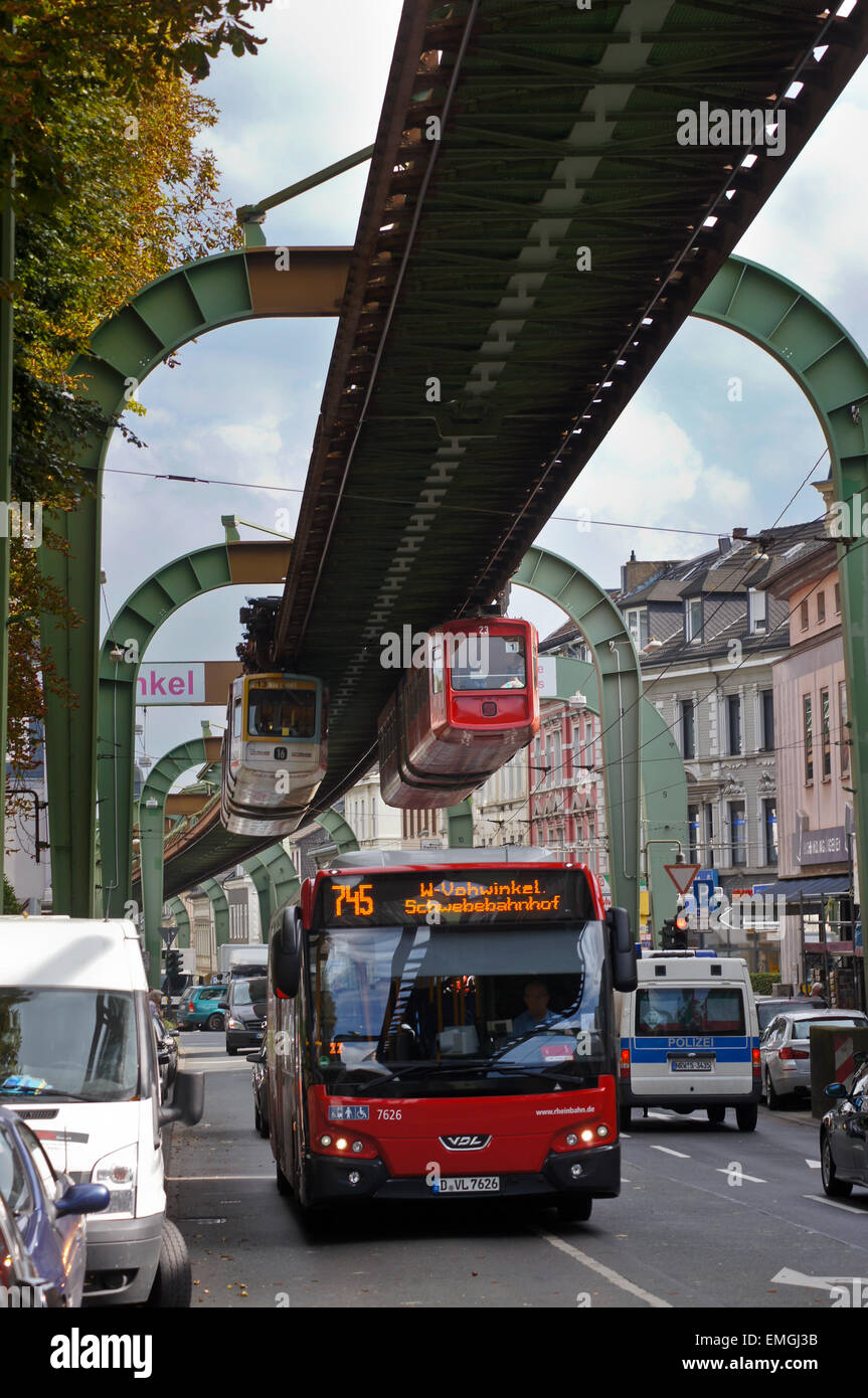 Articulated train, schwebebahn, suspended railway, above a bus on ...
