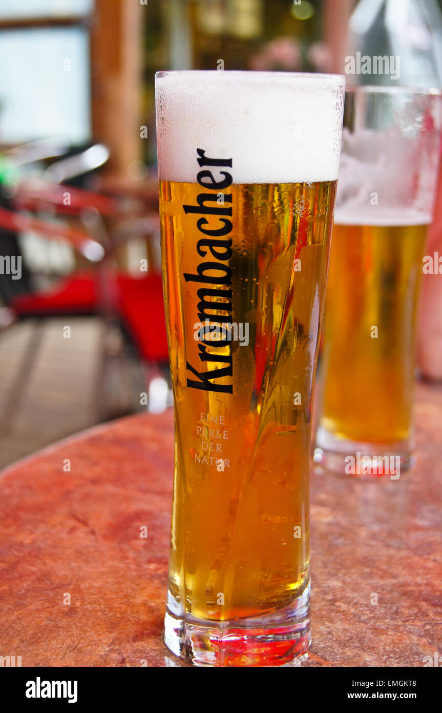 A printed glass of Krombacher Pils lager beer, Wuppertal, Nordrhein-Westfalen, Germany, pub table drinks glasses Stock Photo