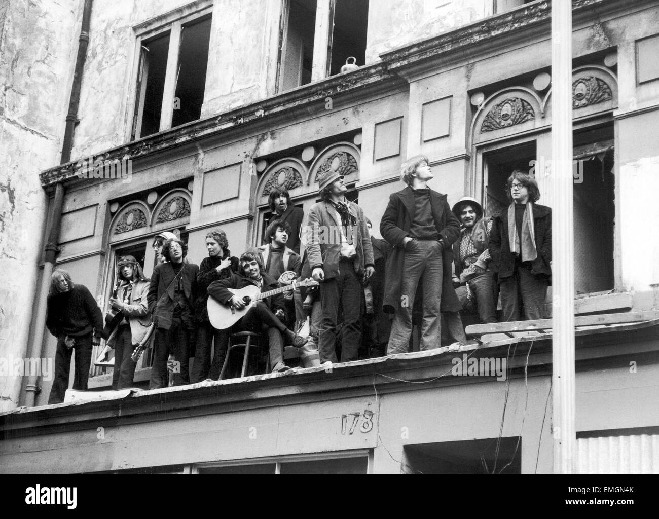 A group of 'Human Rights' sqautters singing We Shall Not Be Moved from the balcony of a derelict hotel they have occupied in London's Drury Lane. They were eventually evicted by a group of demolition workers under orders from the Greater London Council. 27th March 1969. Stock Photo
