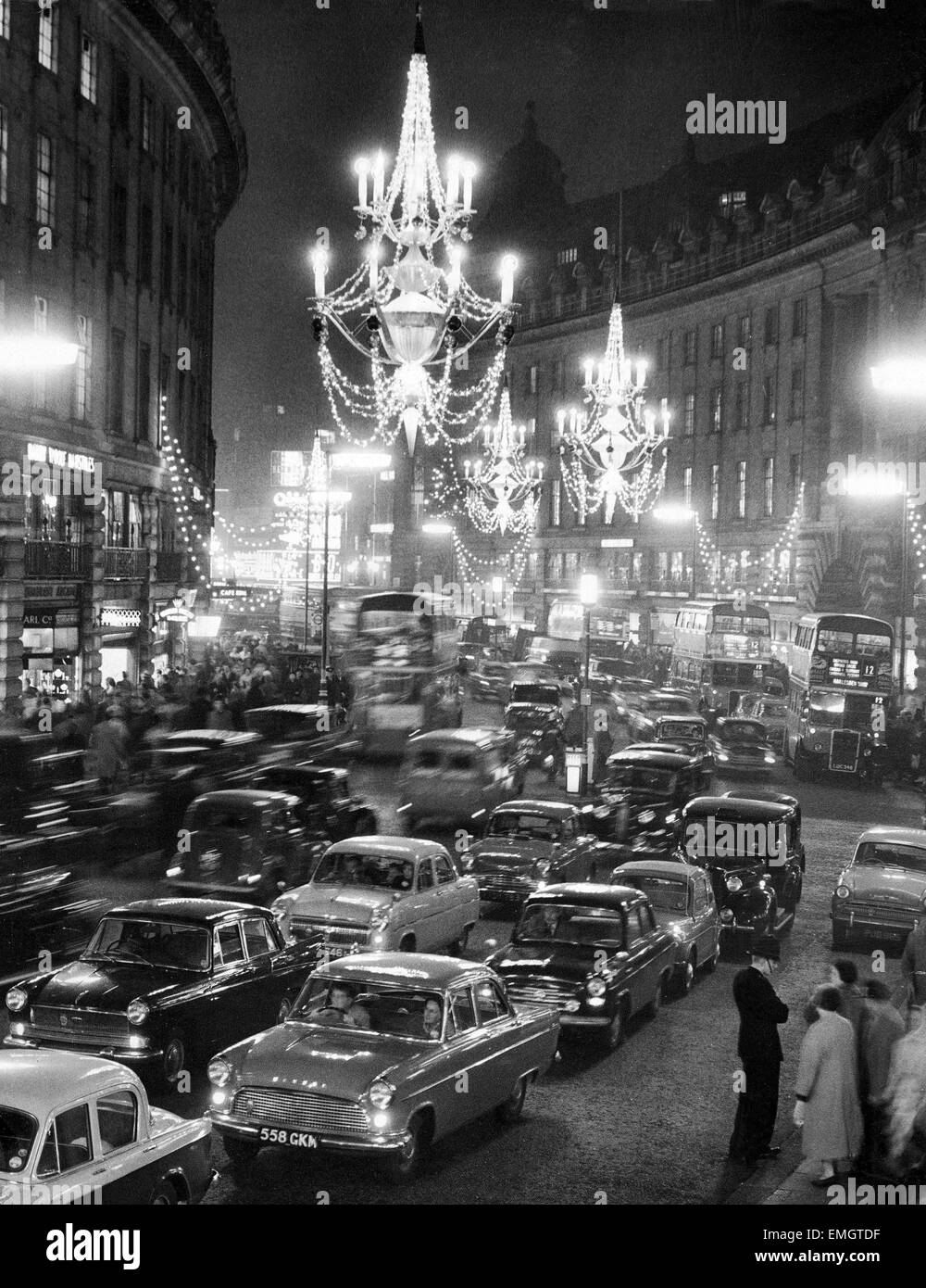 Regent Street packed with traffic as new Christmas lights in the form of chandeliers hanging from the middle of the street are turned on. 26th November 1959. Stock Photo