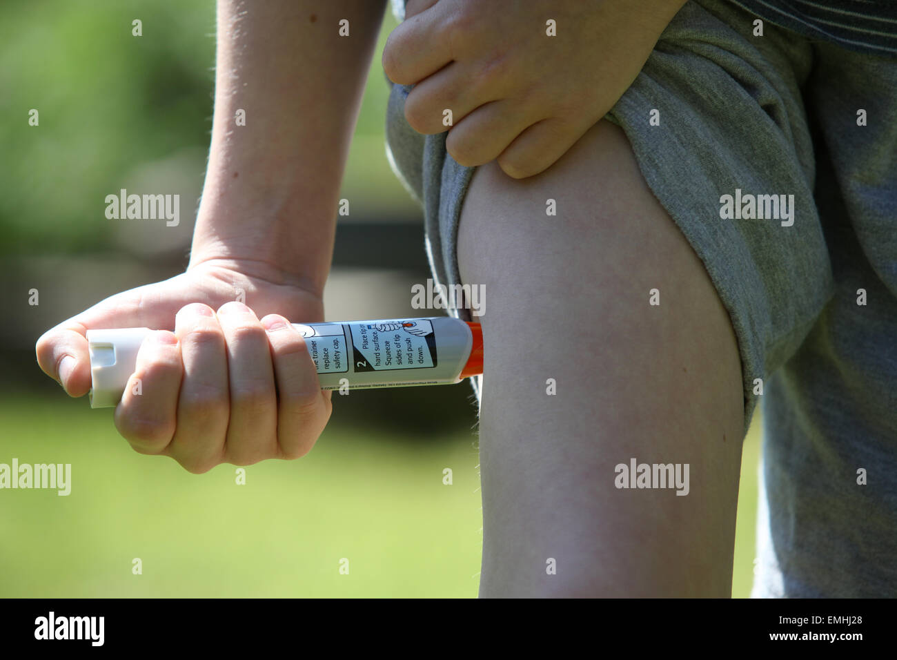 A boy using an epipen in his thigh demonstrating what to do in the