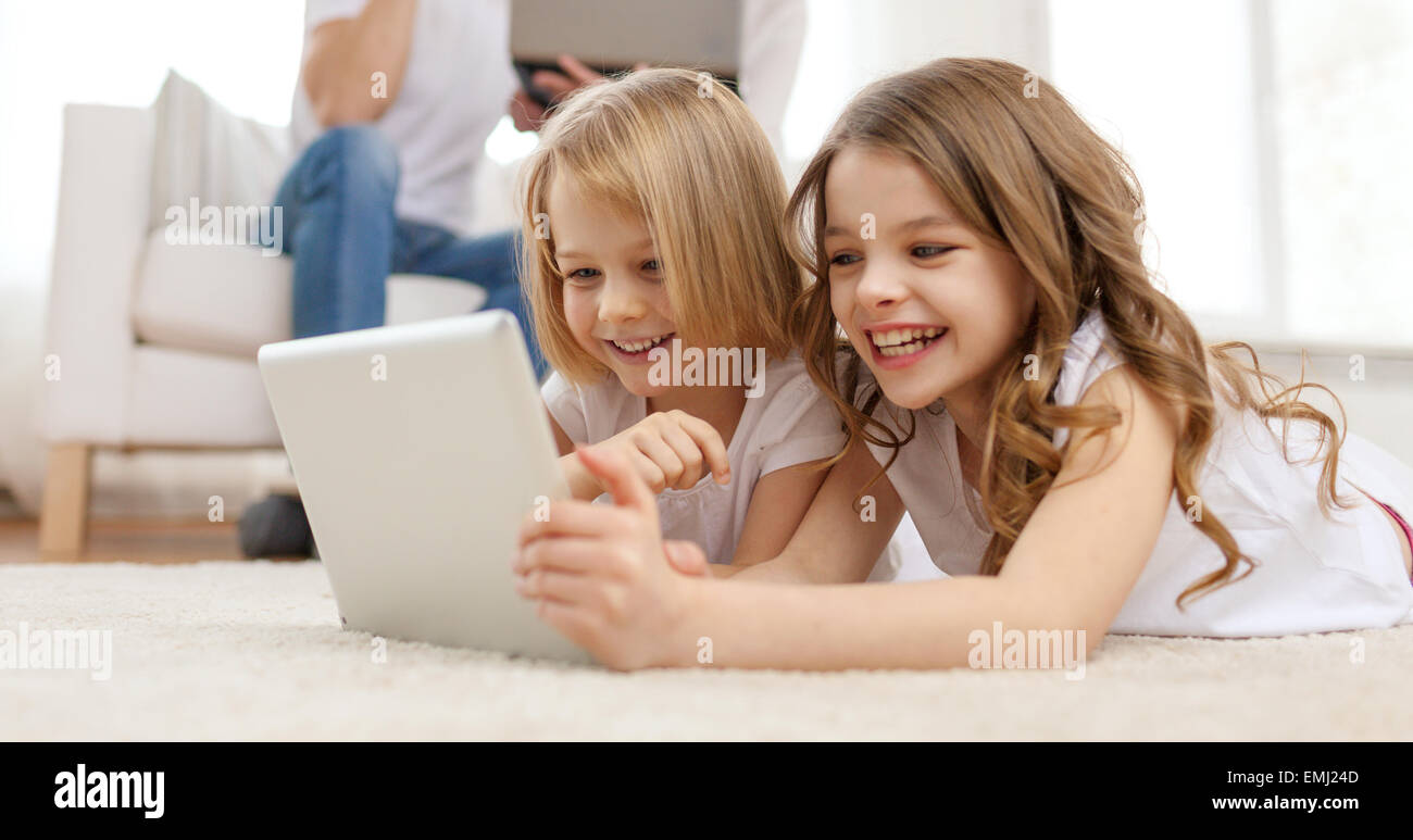 smiling sister with tablet pc and parents on back Stock Photo