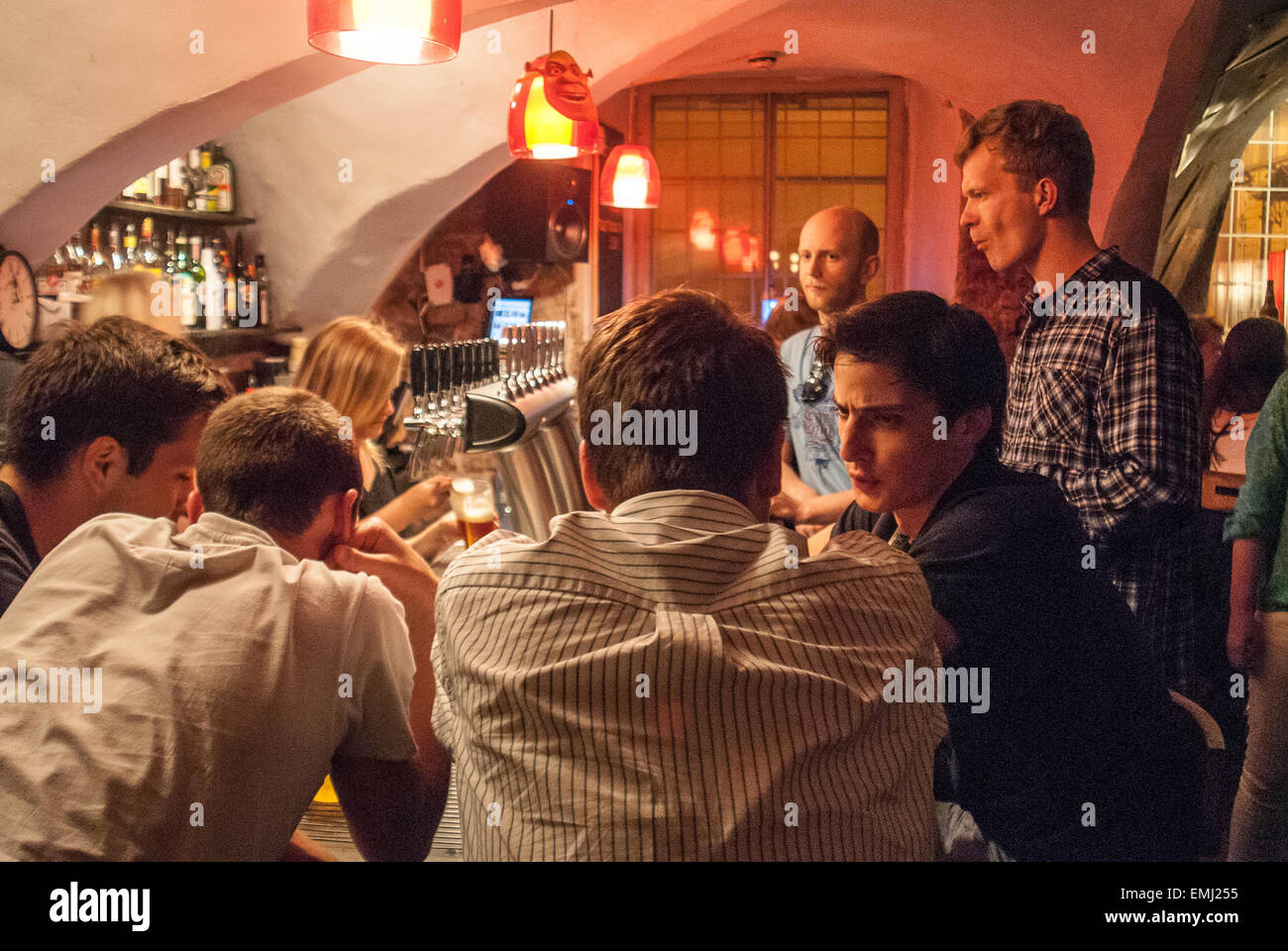 Estonian students talking in a night bar in central Tartu in Estonia. Young men discussing in a pub and drinking beer. Stock Photo