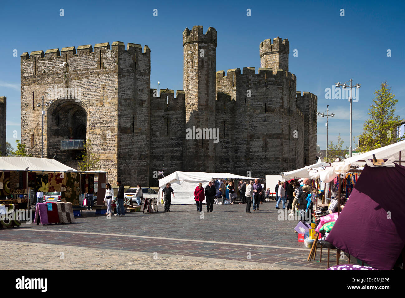 UK, Wales, Gwynedd, Caernarfon, Castle from Y Maes, with market in progress Stock Photo