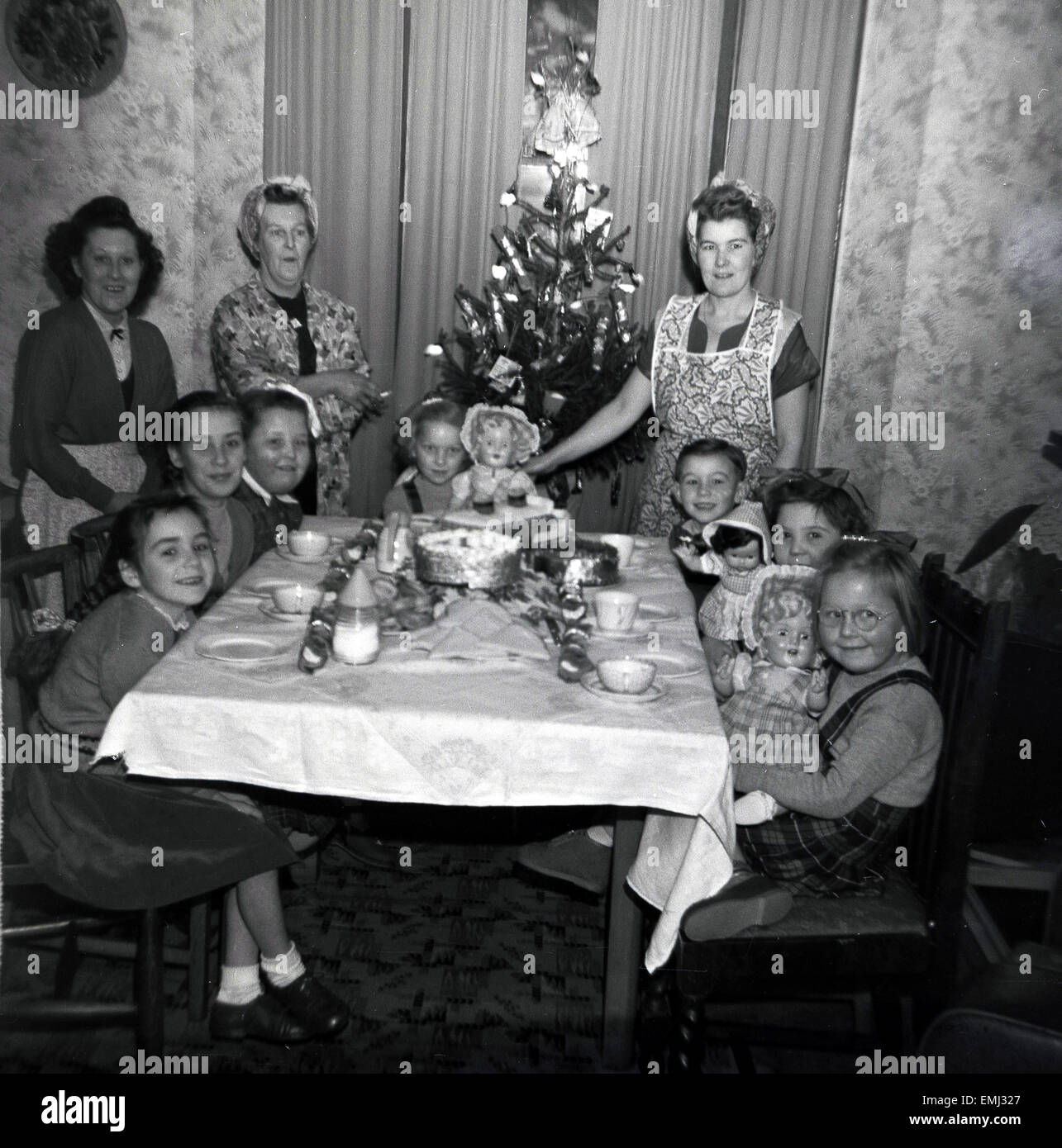 1950s, historical, A happy family xmas. Mums, grandma stand, while the