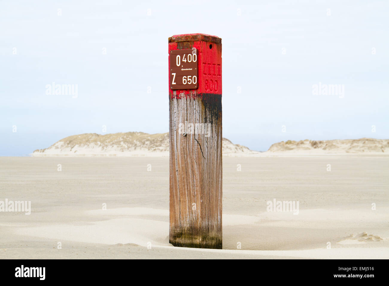 Red pole with distance marking on beach Stock Photo