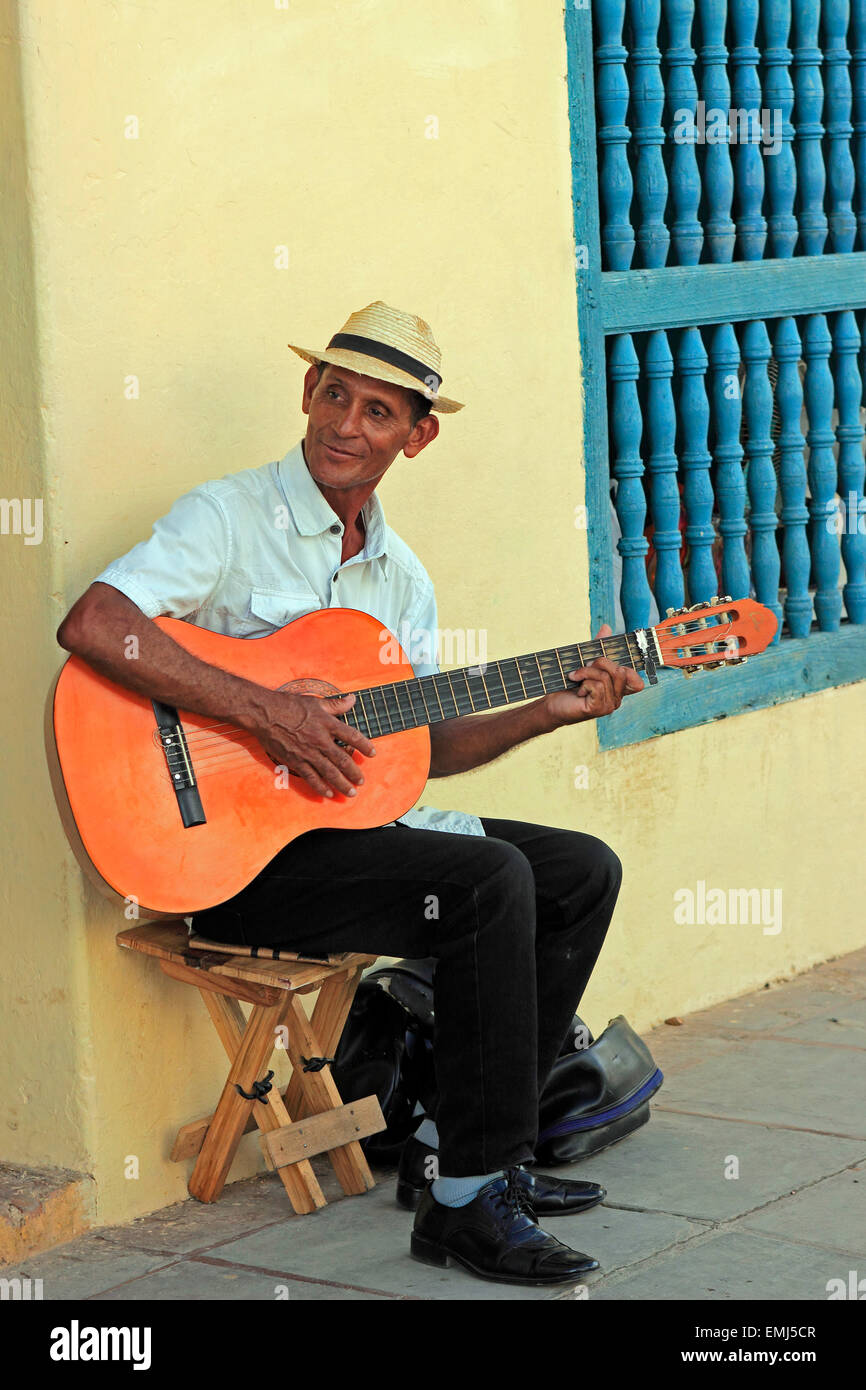 A single guitar player plays music on a colorful street in Trinidad Cuba Stock Photo