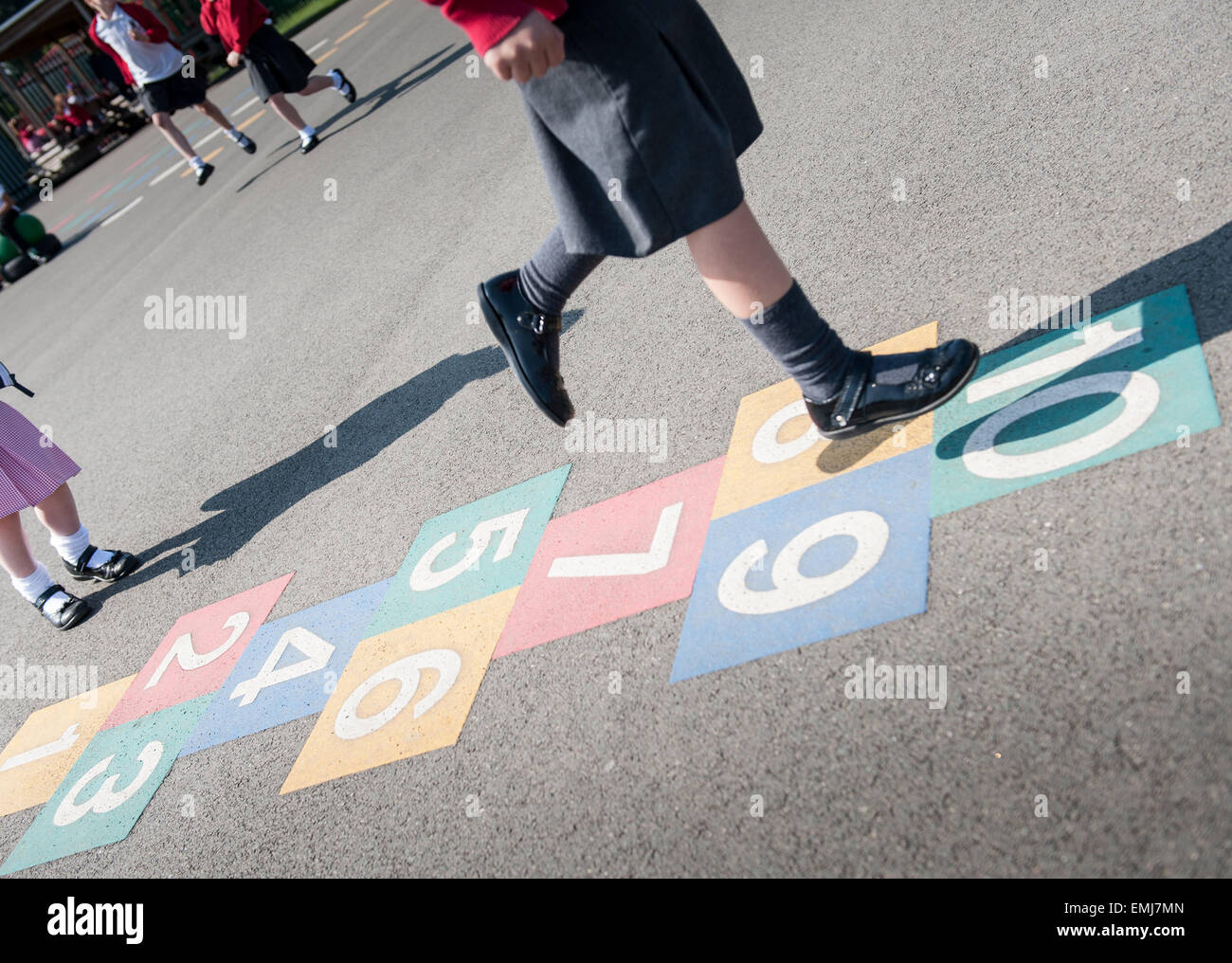A UK schoolgirl plays hopscotch in the school playground Stock Photo