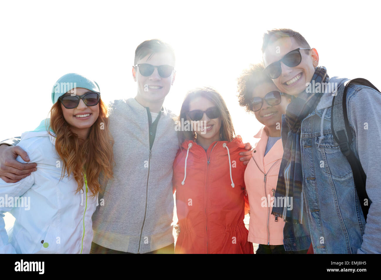 happy teenage friends in shades hugging on street Stock Photo