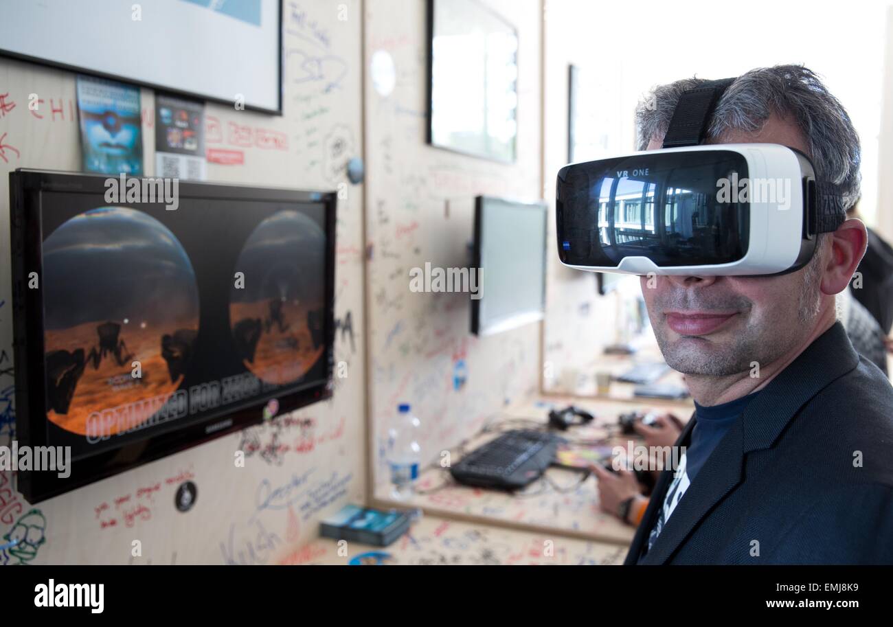 Berlin, Germany. 21st Apr, 2015. Conference participant Frank wears a pair of virtual reality goggles, model Zeiss VR One, as he plays around of 'Troopers VR', which he programmed himself during the computer games conference 'International Games Week' at the 'Kino International' venue in Berlin, Germany, 21 April 2015. The 'International Games Week' runs from 21 April to 26 April 2015. PHOTO: JOERG CARSTENSEN/dpa/Alamy Live News Stock Photo