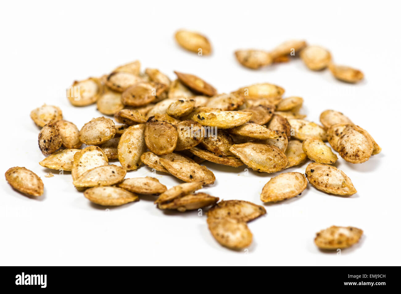 Roasted butternut squash seeds on white background Stock Photo