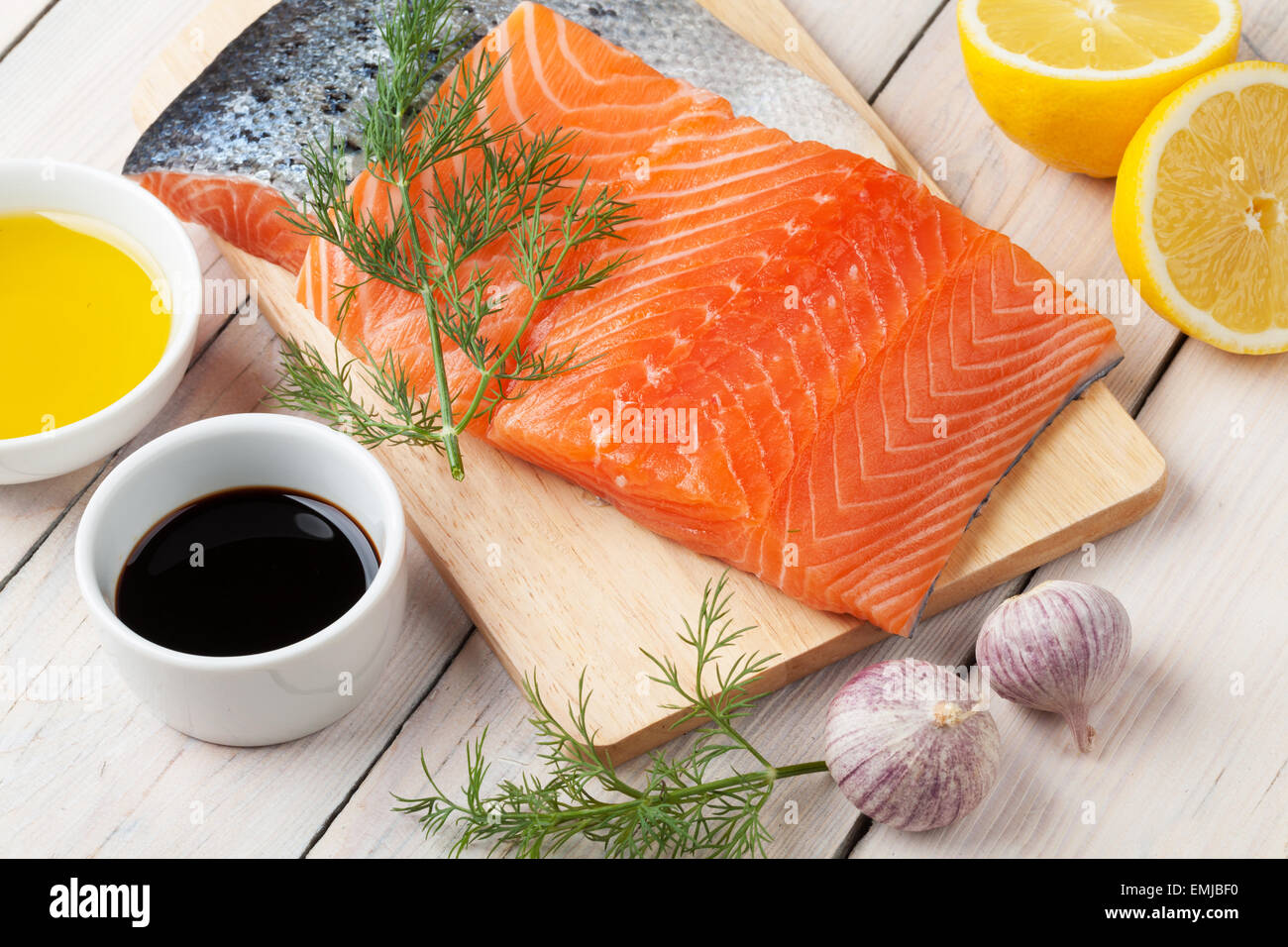 Salmon, spices and condiments on wooden table Stock Photo