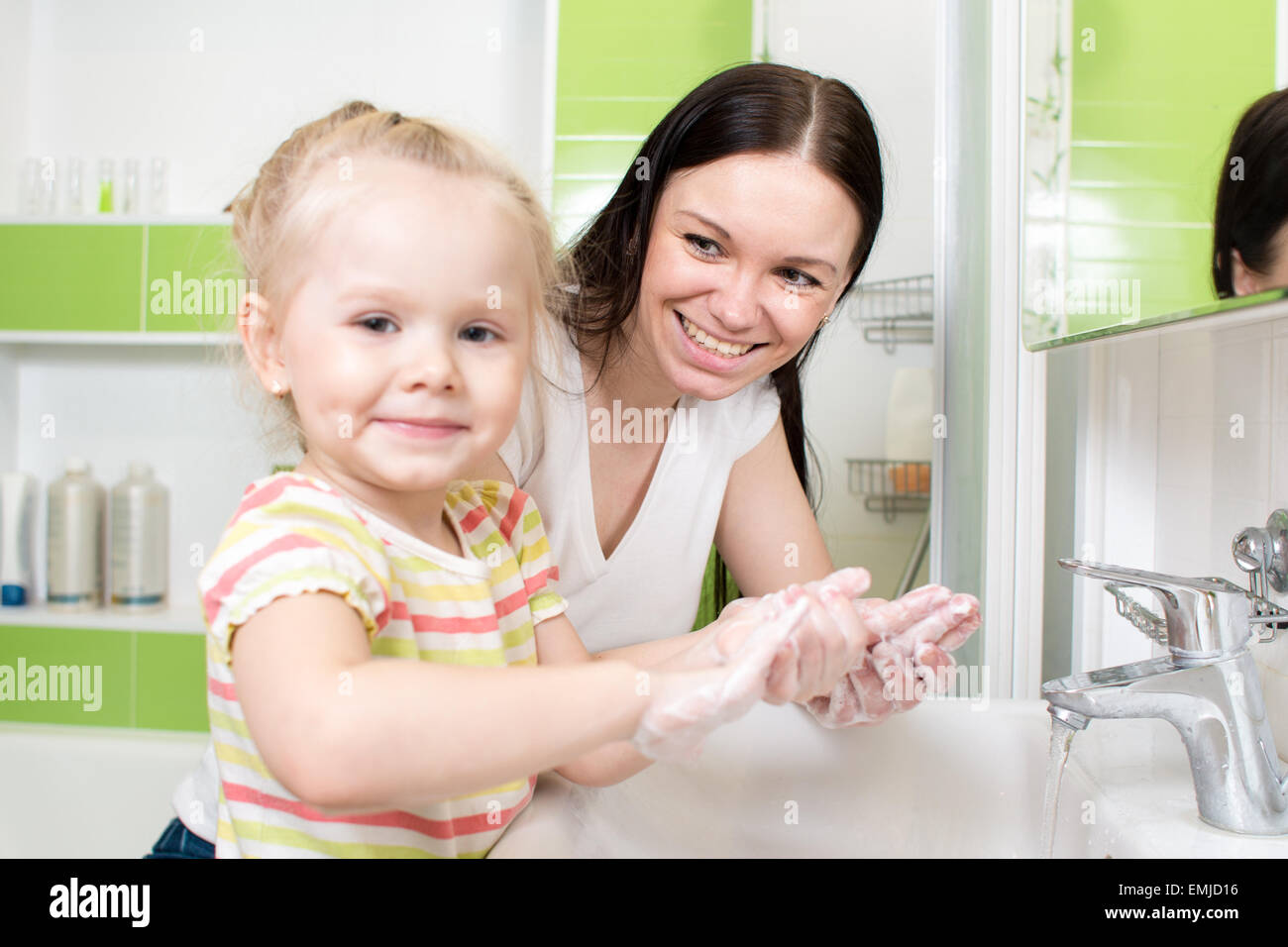 young woman and her daughter washing hands with soap in bathroom Stock ...