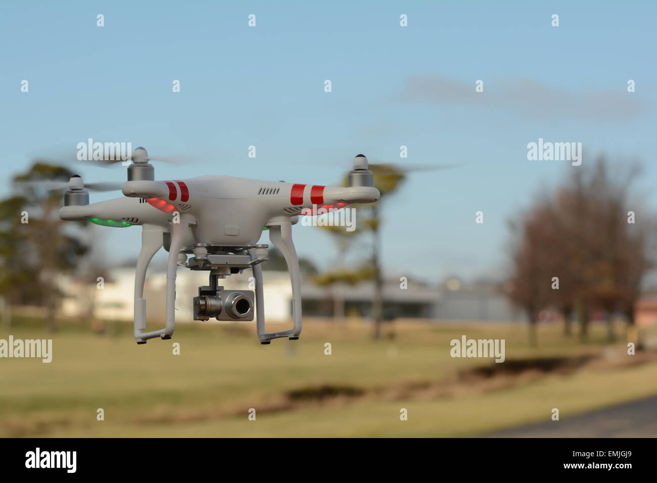 Phantom aerial drone flying near a park.   Remote controlled aerial quadracopter in flight blue sky. Stock Photo