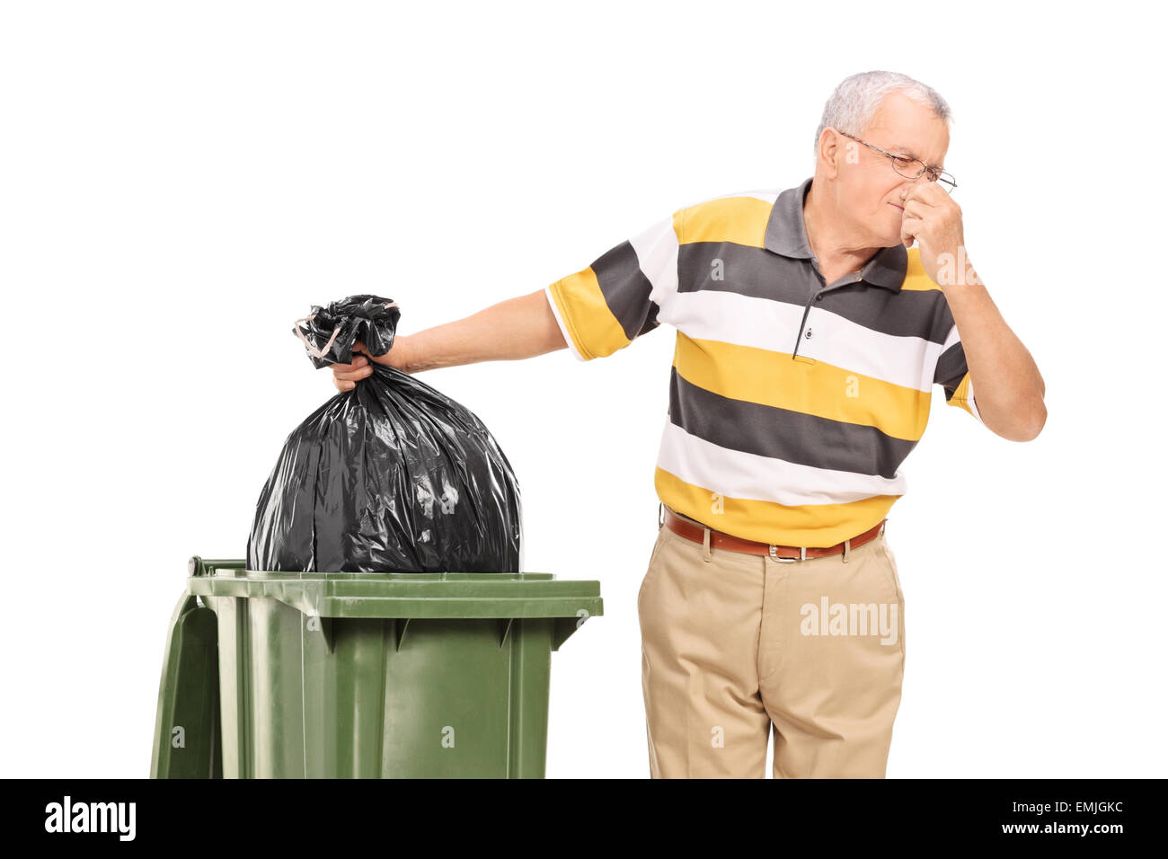 Senior throwing away a stinky bag of trash isolated on white background Stock Photo