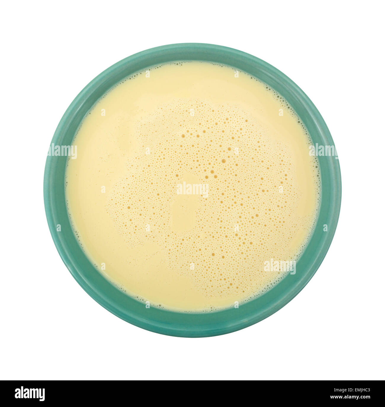 Top view of a bowl filled with evaporated milk on a white background. Stock Photo