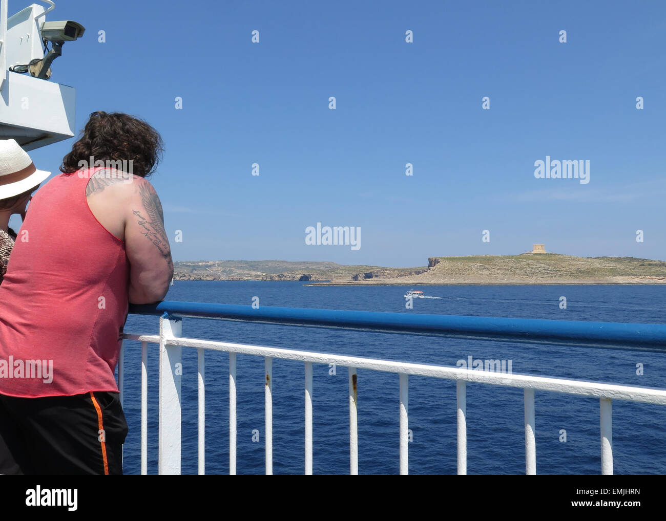 Fat bloke with tattoos leaning on the rails of a boat Stock Photo