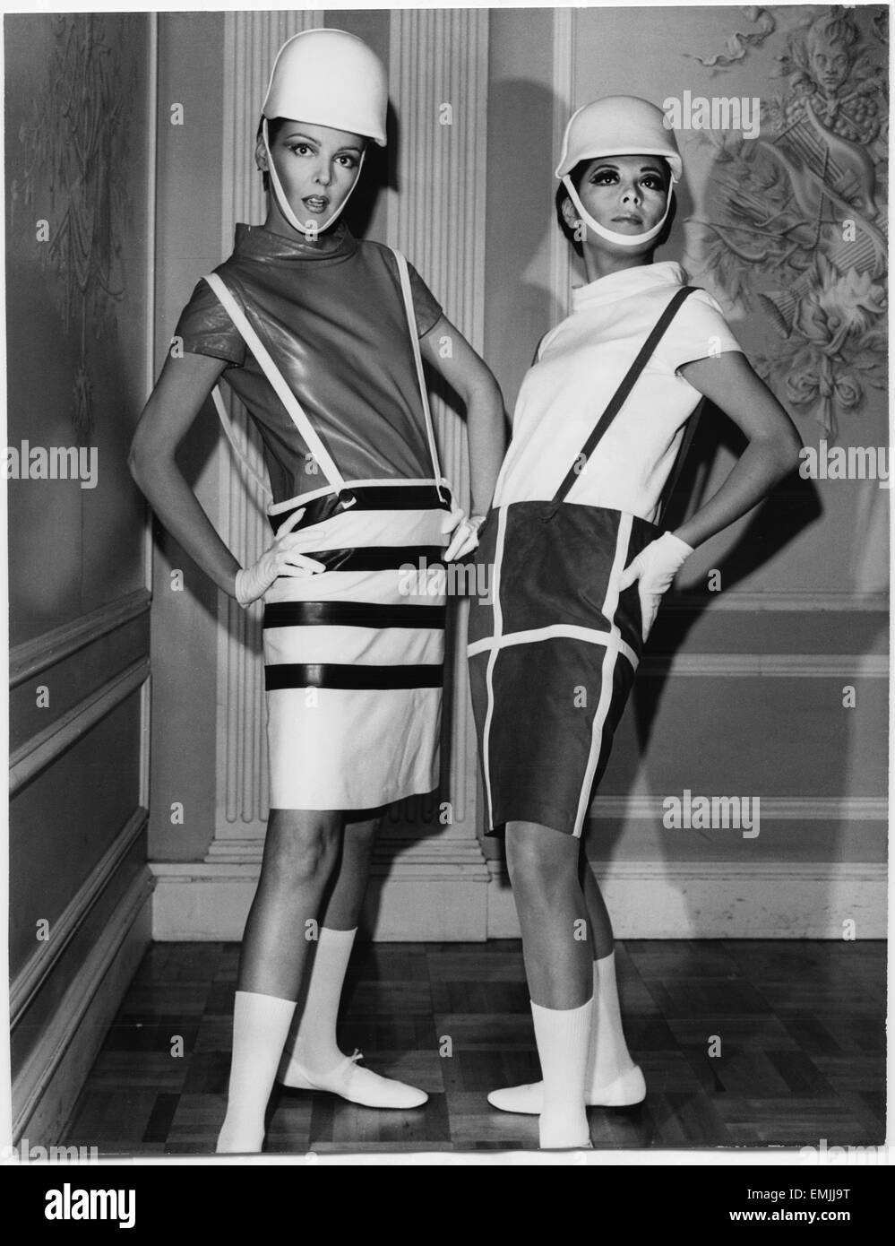 Two Fashion Models Wearing Sleek Interpretations of Andre Courreges’ Suspender Outfits Featuring Barrel Skirts with Button-Attached Suspenders and Leather Cowl-Neck Blouses, Presented by Samuel Robert, New York City, 1965 Stock Photo