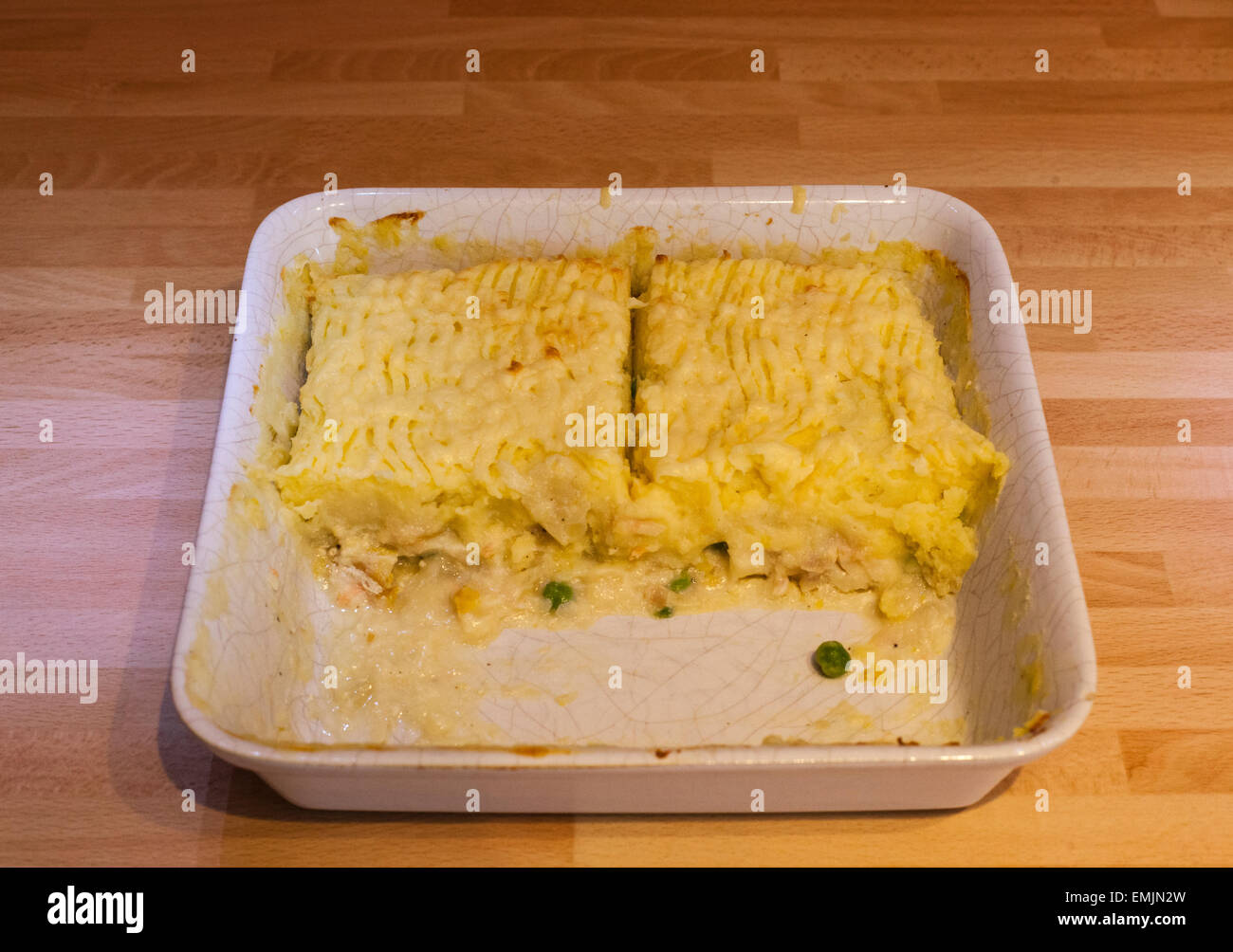 Fish pie half filling a pie dish, the other half having been served Stock Photo
