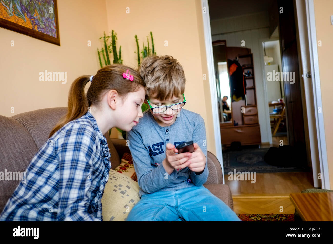 kid kids sister brother child children play mobile phone telephone happy 6 7 8 9 10 old Stock Photo