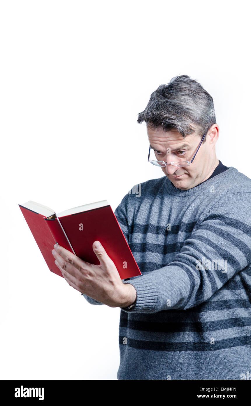 Guy finding holding a book at quite a distance to be able to read Stock Photo