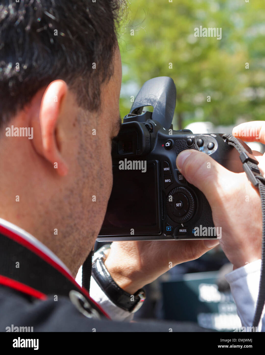 Man looking through viewfinder of dSLR camera - USA Stock Photo