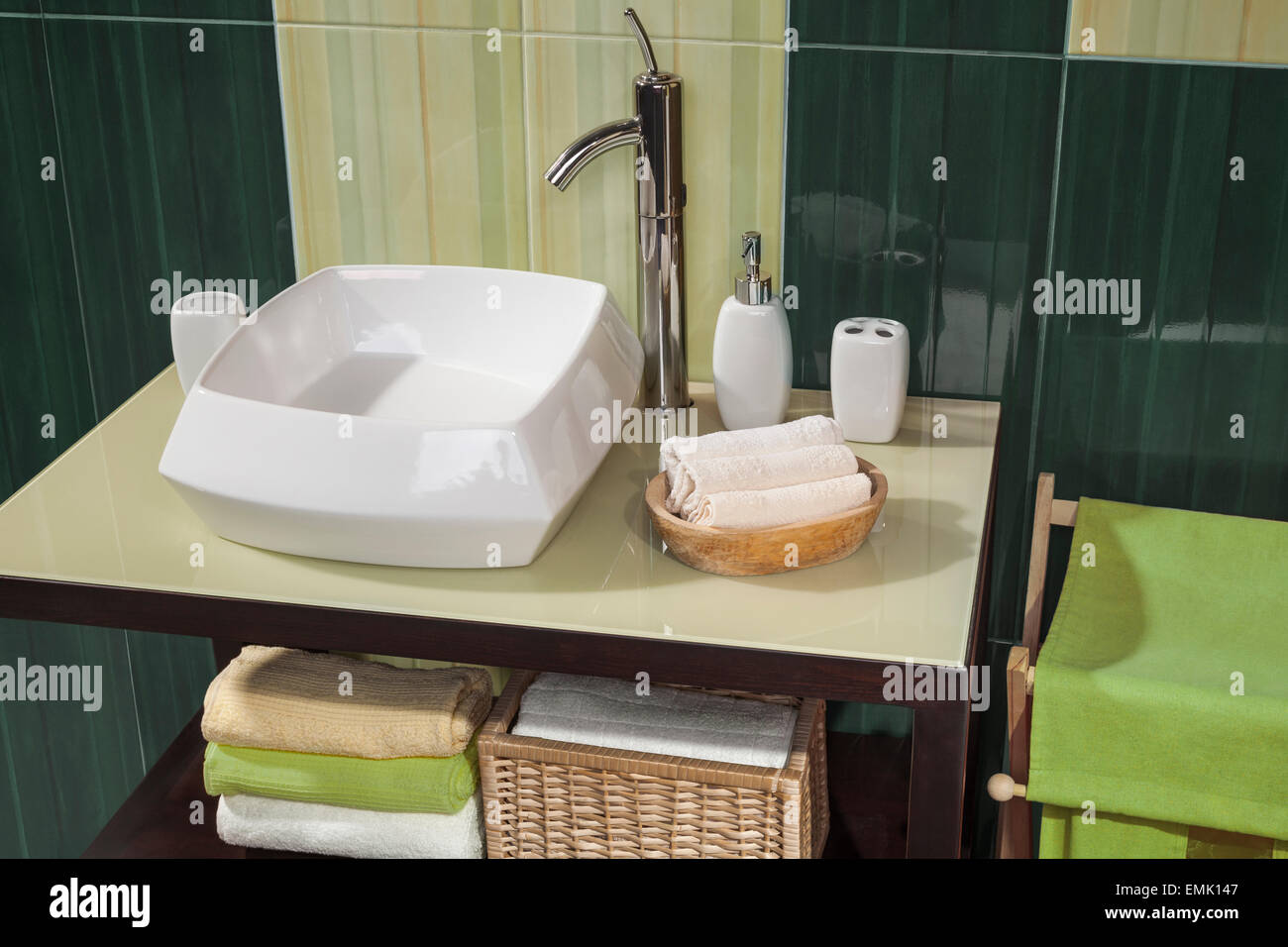 detail of a modern bathroom with sink and accessories, bathroom cabinet and green bathroom tiles Stock Photo