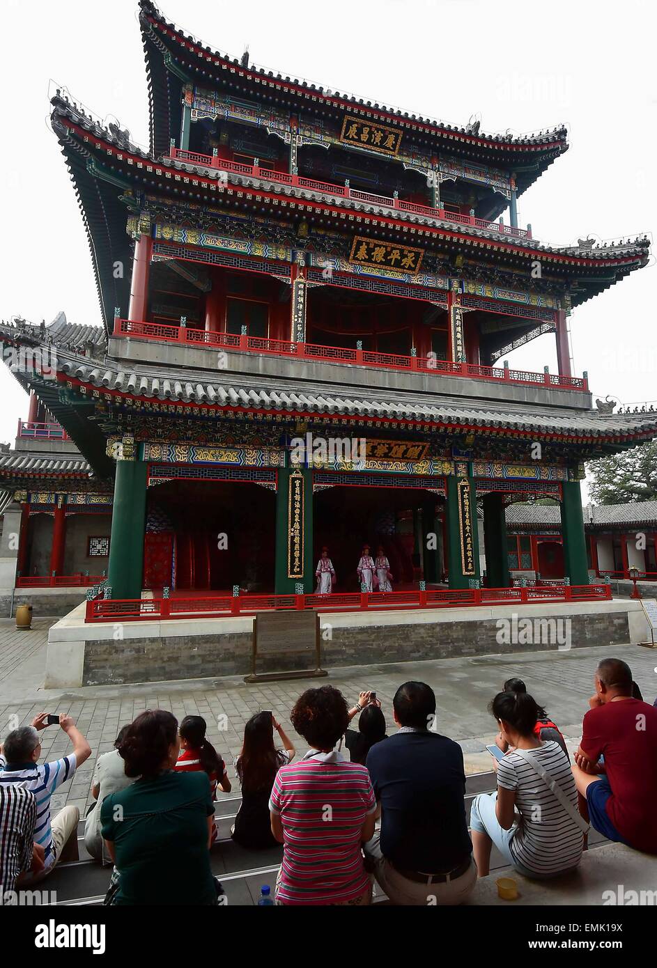 Beijing, China. 31st Aug, 2014. People watch a performance in front of the stage of Dehe Garden in the Summer Palace of Beijing, capital of China, Aug. 31, 2014. China's performing stage is an essential part of traditional Chinese architecture. Most well-preserved ancient stages were built in Ming Dynasty (1368-1644) and Qing Dynasty (1644-1911). It generally consists of indoor and outdoor types. The main construction materials are wood, brick and stone. Its unique acoustics property has become an important object for experts. © Wang Song/Xinhua/Alamy Live News Stock Photo