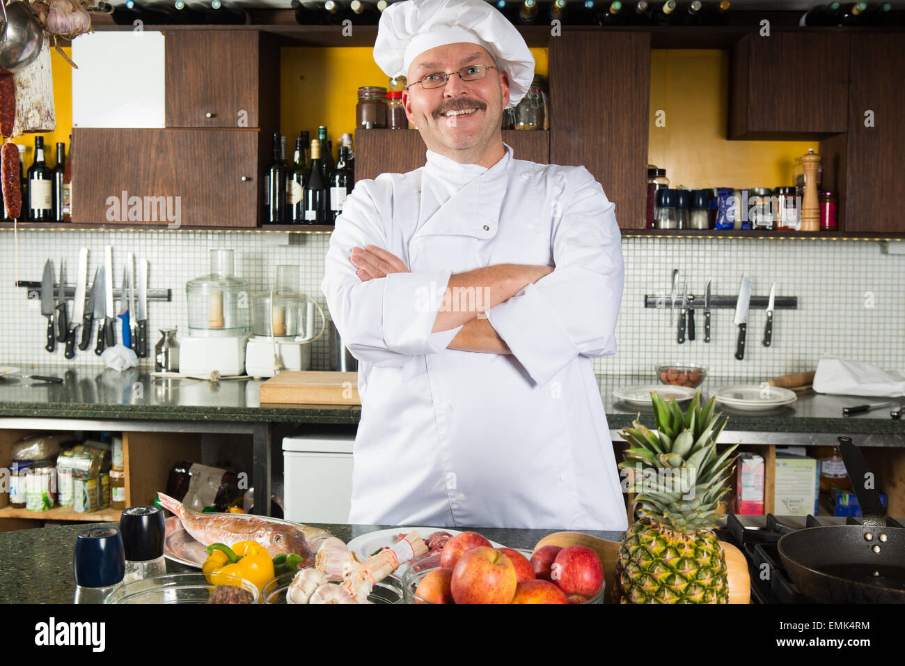 Mature male chef standing in his kitchen ready to start cooking Stock ...