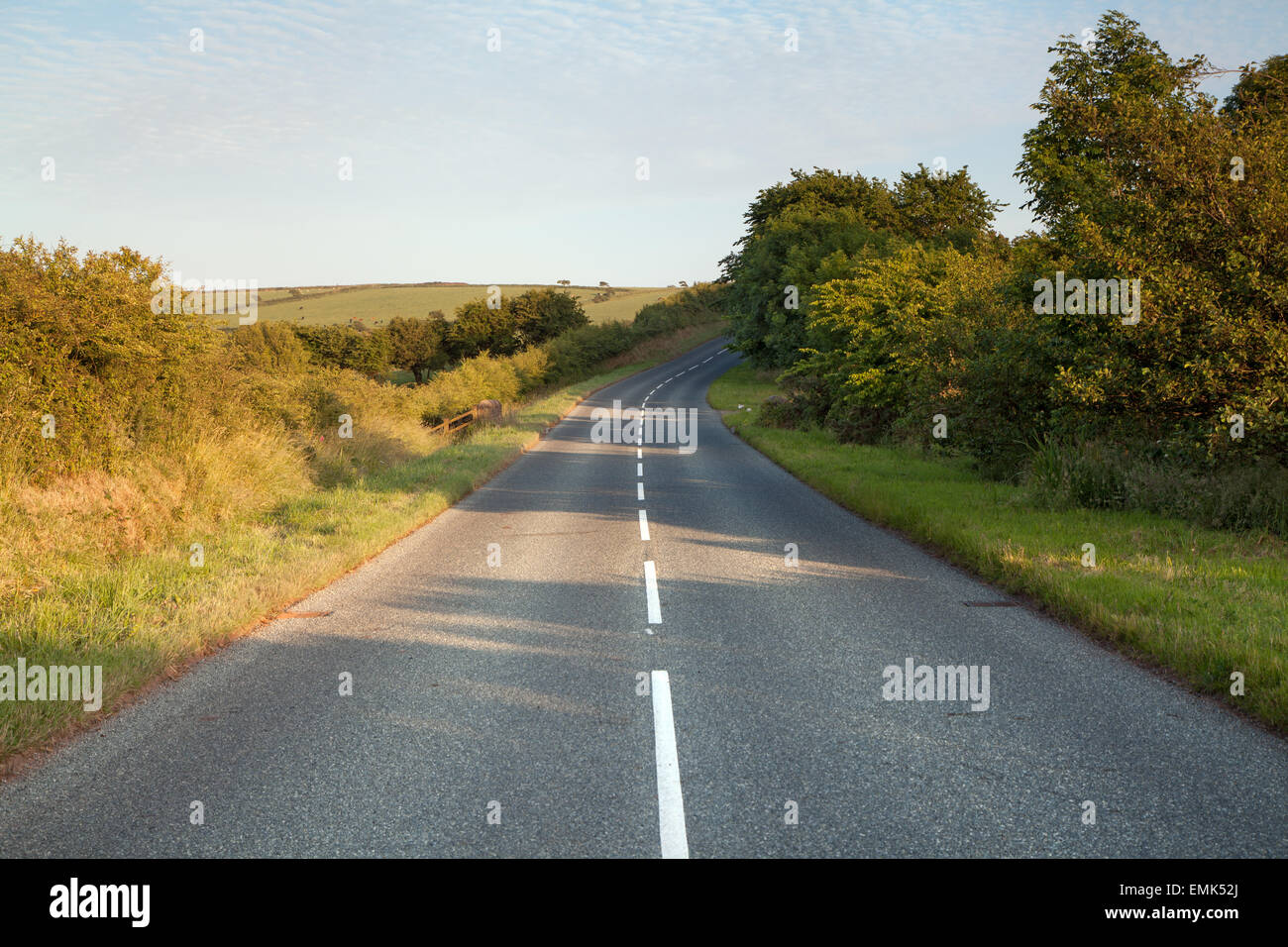 Road running through Pembrokeshire countryside at sunset Stock Photo