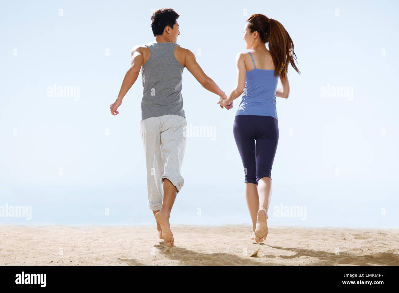 The romantic lovers walking on the beach Stock Photo