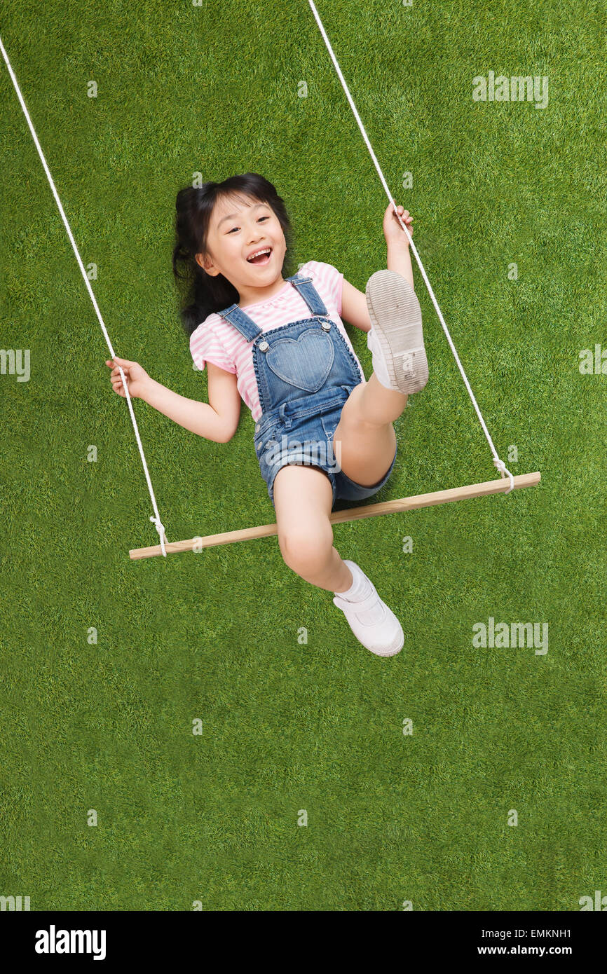 A lovely little girl swing on the grass Stock Photo - Alamy