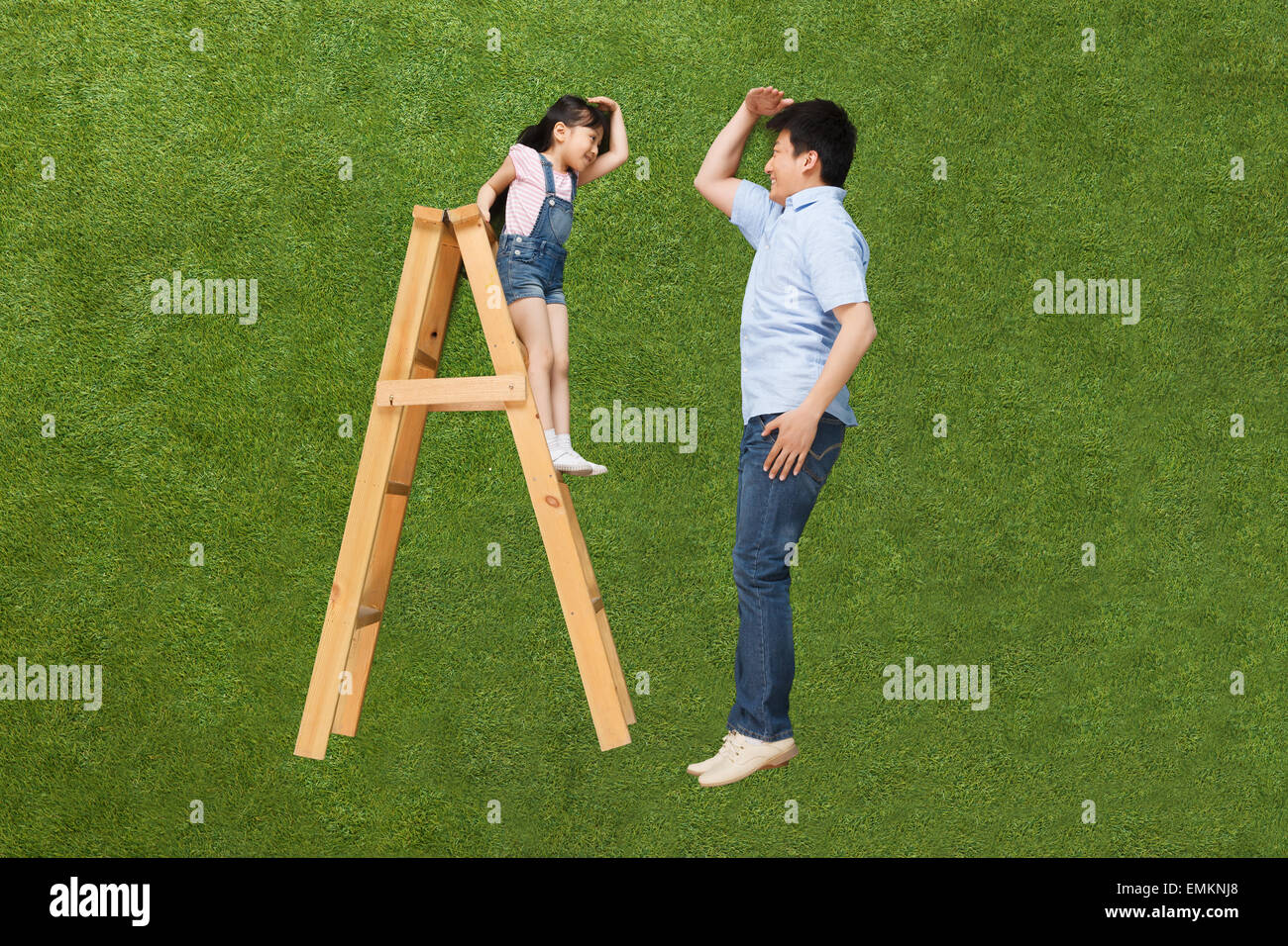 The girl stood on the ladder and the father than the height Stock Photo