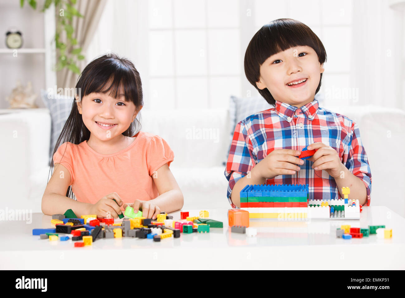 Two children playing with toys in the living room Stock Photo - Alamy