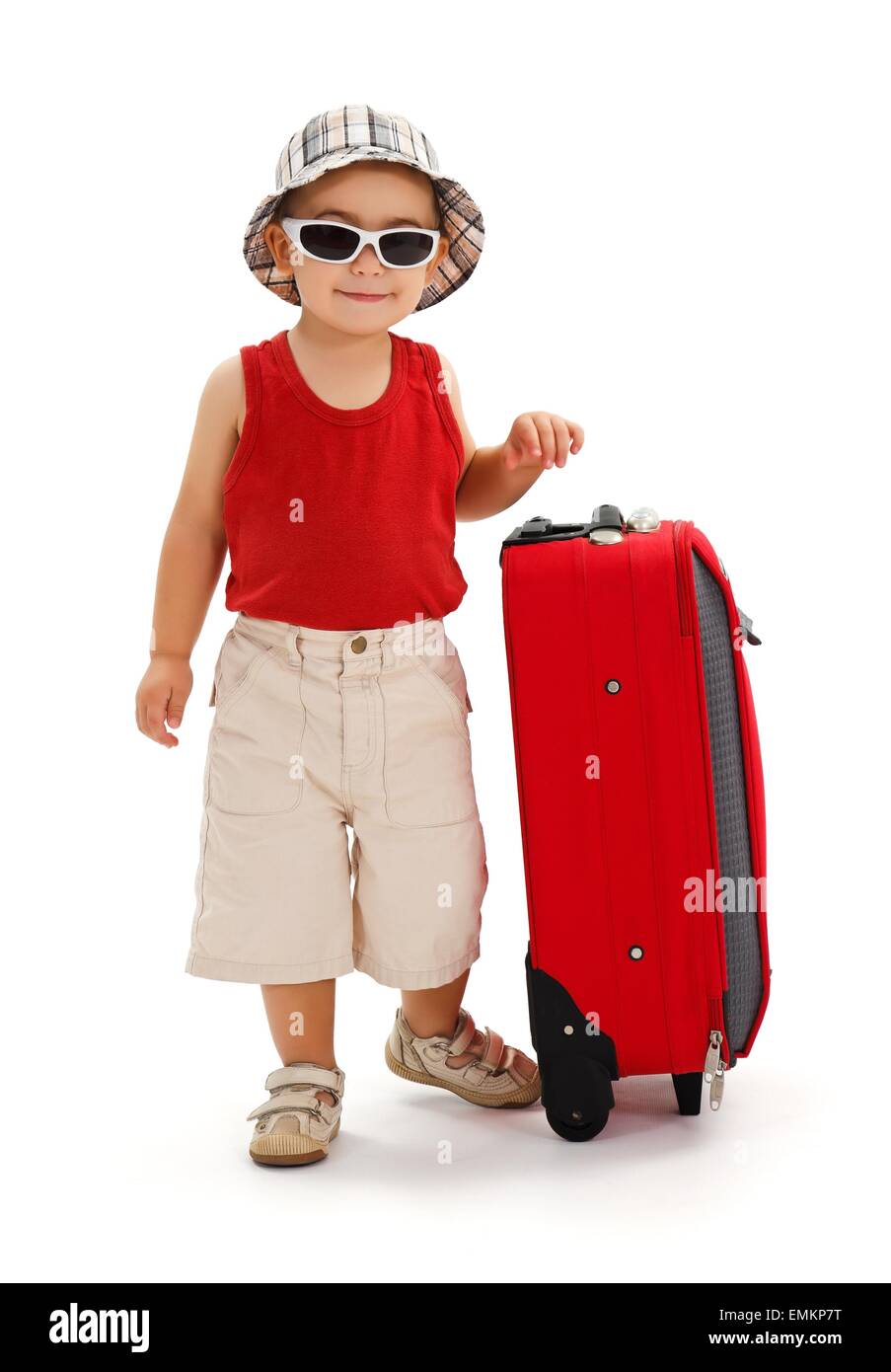 Little boy in sunglasses and hat, standing near luggage, ready for summer vacation Stock Photo