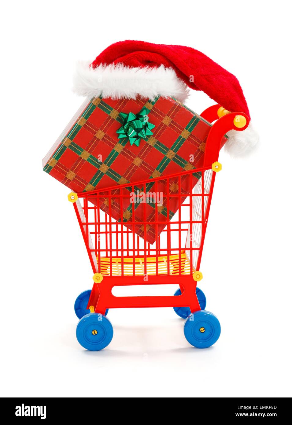 Toy shopping cart with big Christmas present, Santa hat on the box Stock Photo