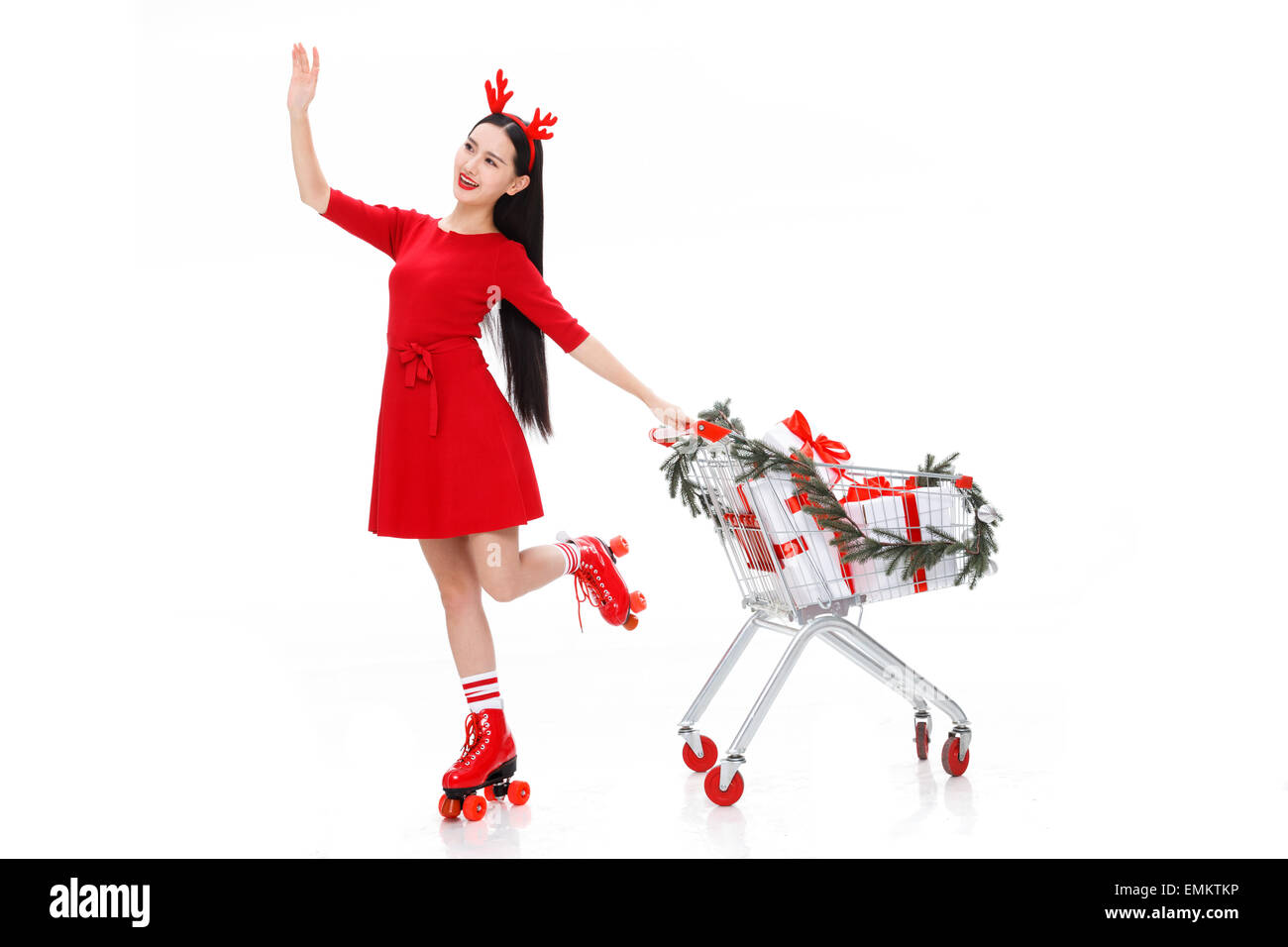 A young woman took the shopping cart to buy Christmas presents Stock Photo