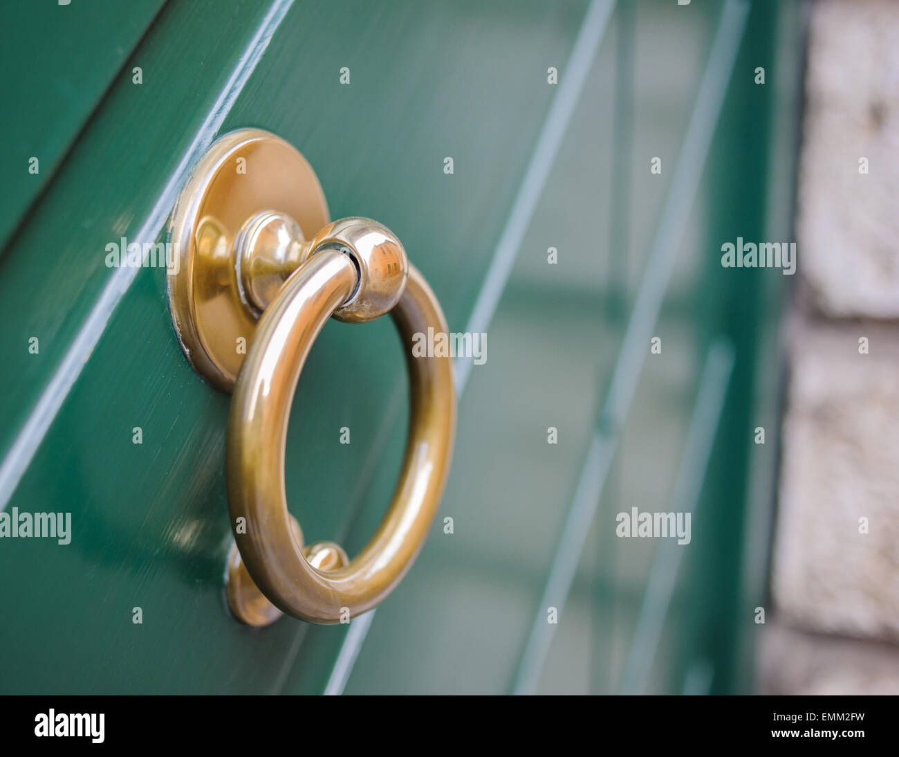 knocker ring of brass on a wooden door colored green Stock Photo