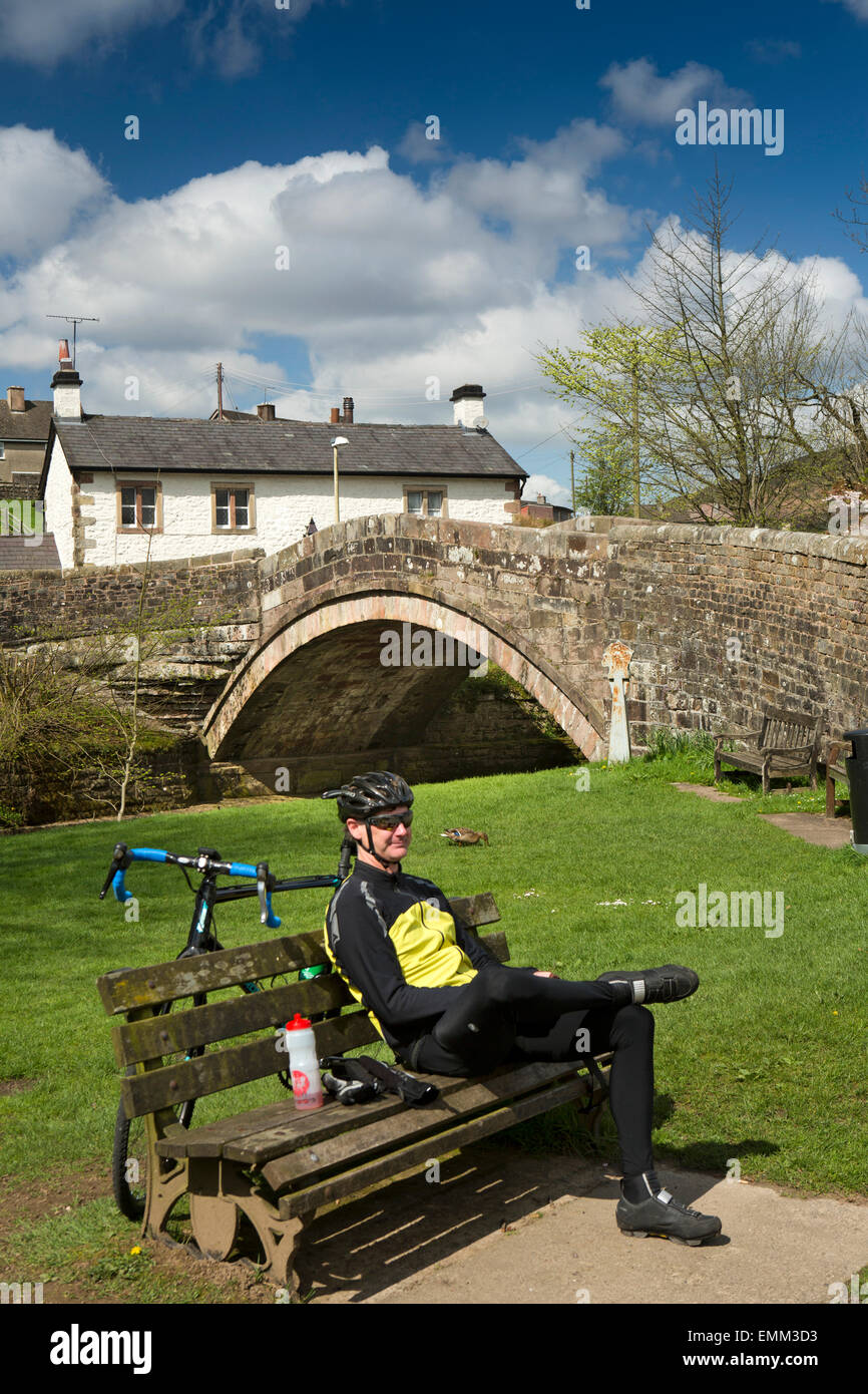 UK, England, Lancashire, Trough of Bowland, Dunsop Bridge, cyclist resting by River Dunsop Stock Photo