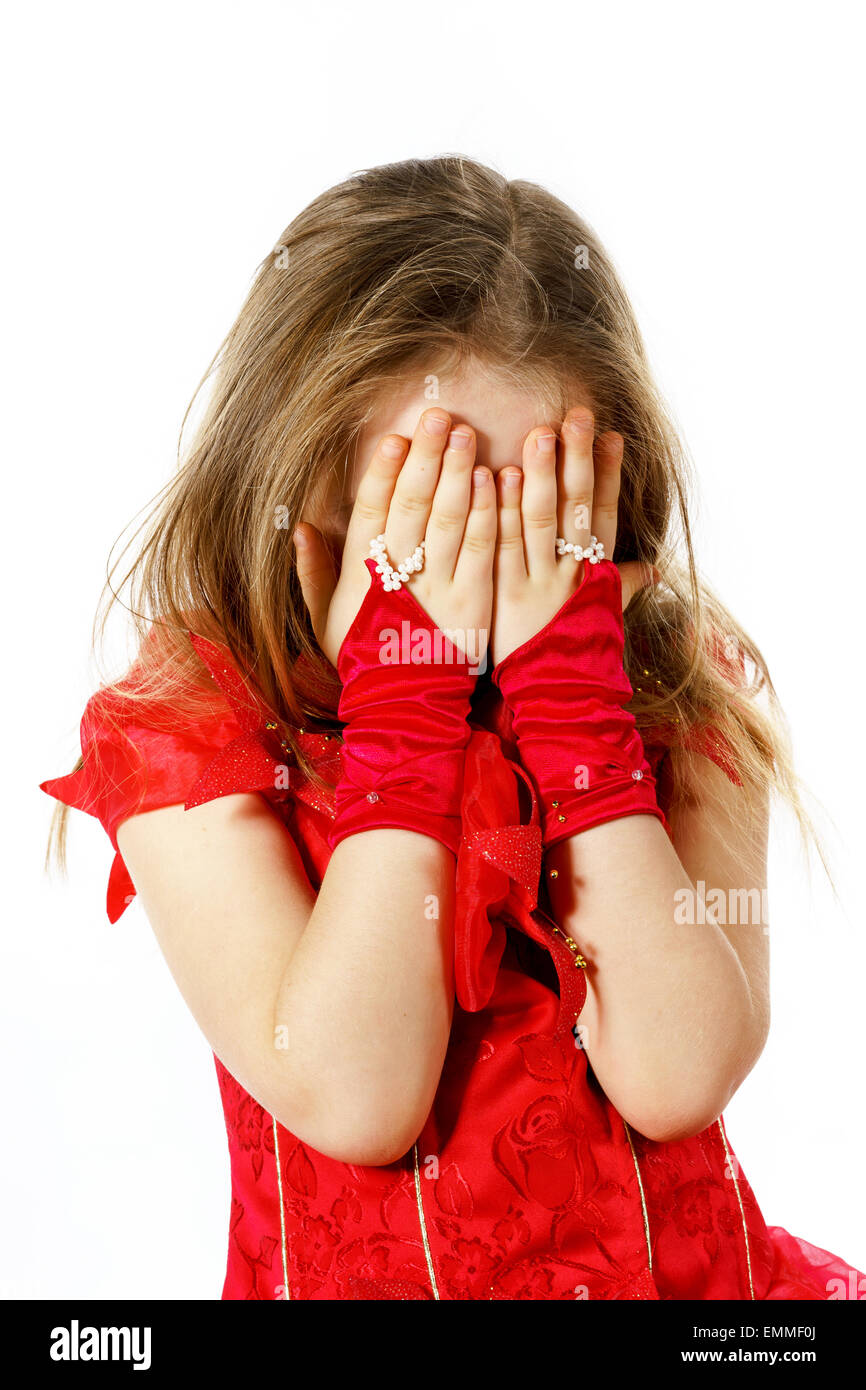 Cute little girl dressed in red hiding face by her hands Stock ...