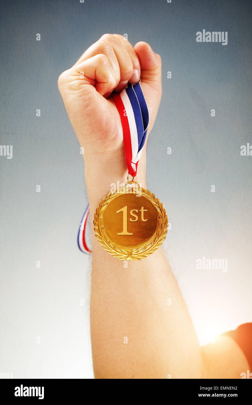 Winning first place hand holding gold medal Stock Photo
