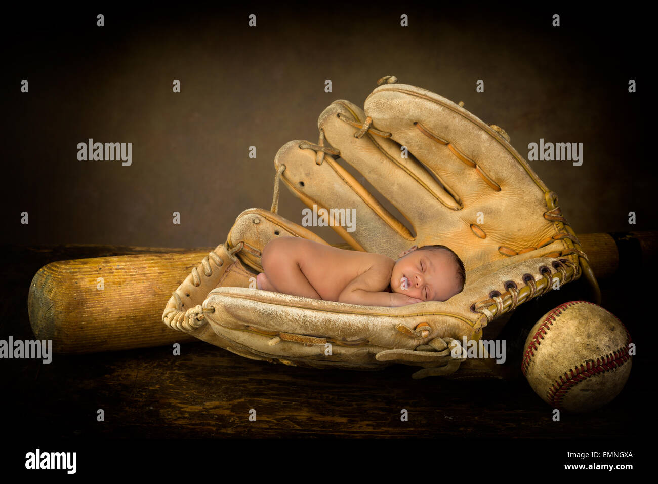 Sleeping newborn baby sleeping in an old baseball glove Stock Photo