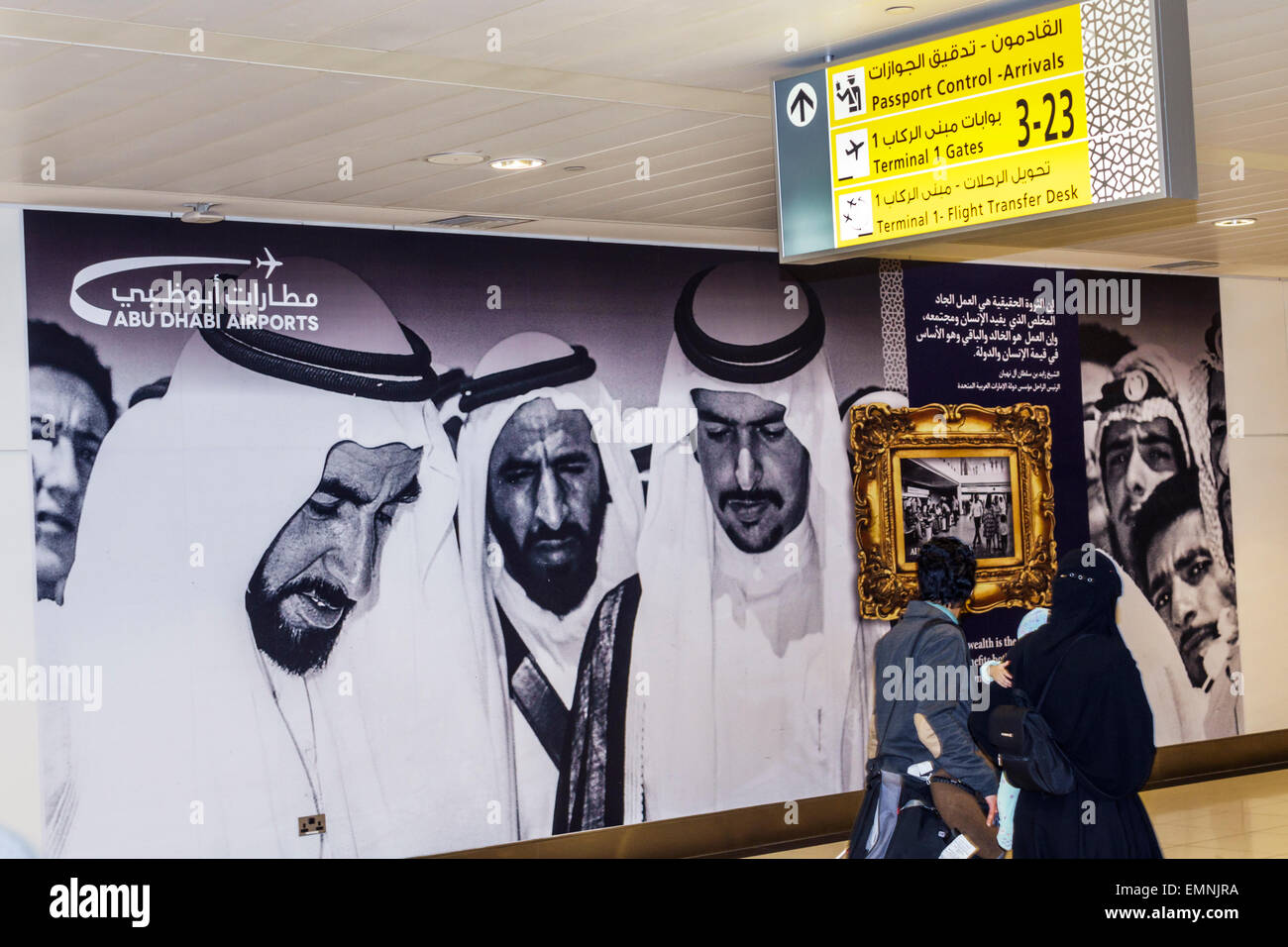 Abu Dhabi United Arab Emirates UAE,International Airport,AUH,terminal,gate,mural,billboard,sheik,Arab,keffiyeh,agal,adult adults man men male,visitors Stock Photo
