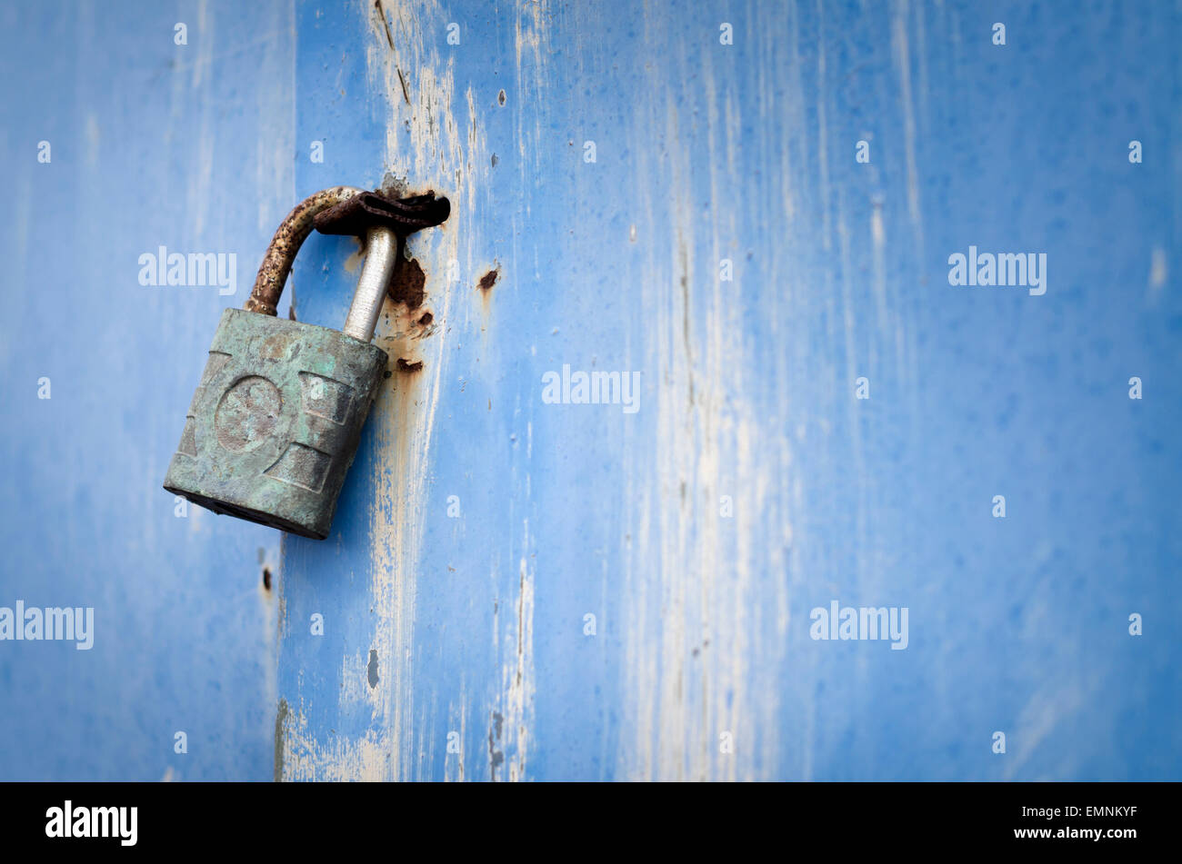 Rusty padlock on battered blue cabinet Stock Photo