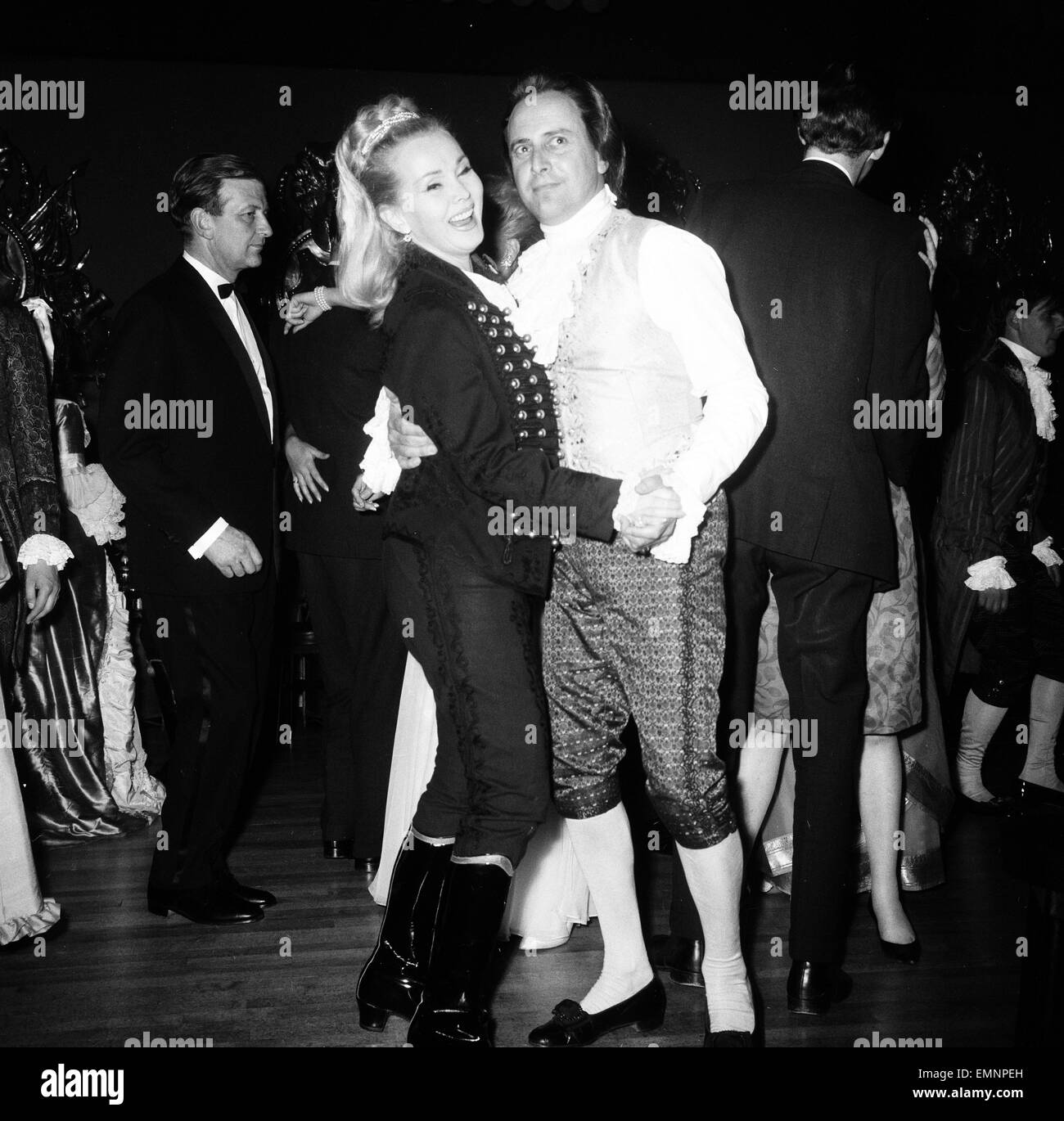Actress Zsa Zsa Gabor holds a party this evening for over 200 guests at Les Ambassadeurs Club, Hamilton Place, London 9th July 1964. Pictured dressed in Hussar Uniform. Pictured dancing with tv personality David Jacobs. Stock Photo
