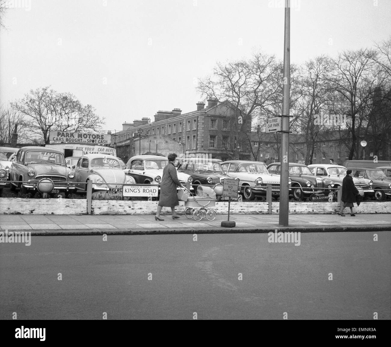 A woman and a pram pass a deserted second hand car lot in the Kings Road Chelsea. 23rd February 1960 Stock Photo