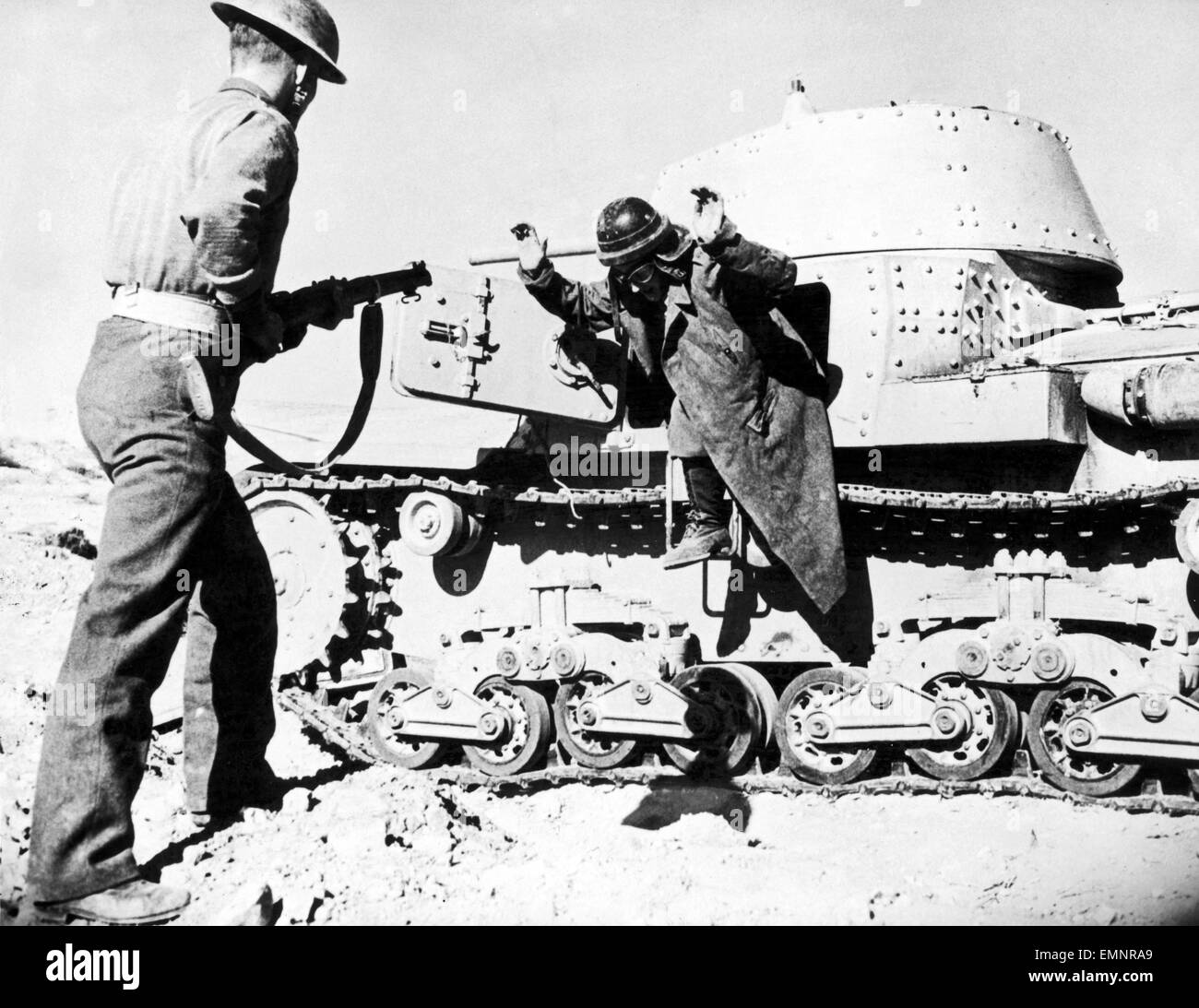 Axis defeat in Cyrenaica. A member of the crew of a captured Italian tank surrendering to a British infantryman. 5th January 1942 Stock Photo
