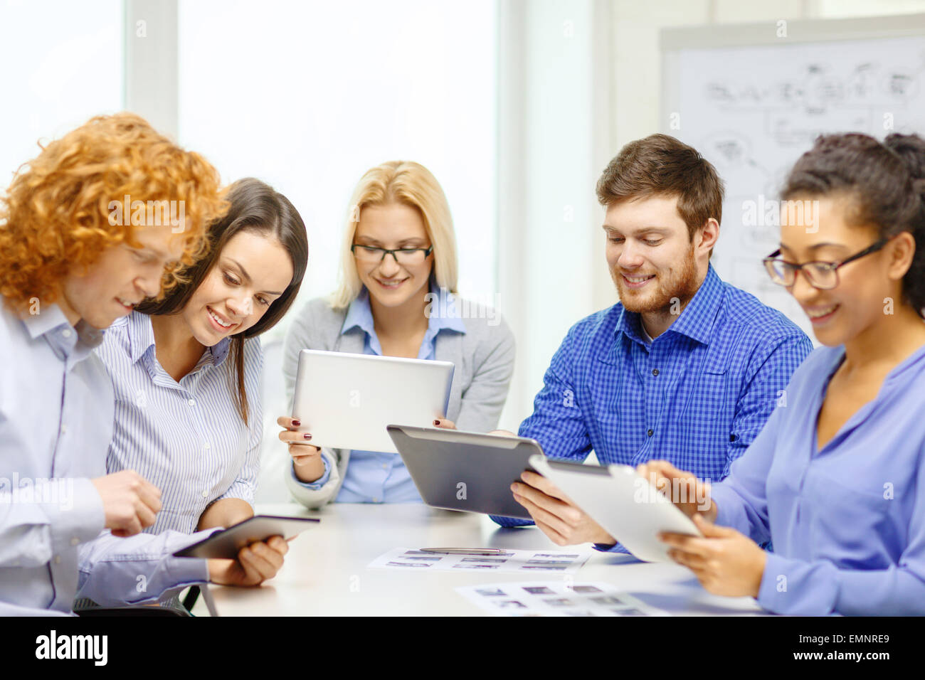 smiling team with table pc and papers working Stock Photo - Alamy