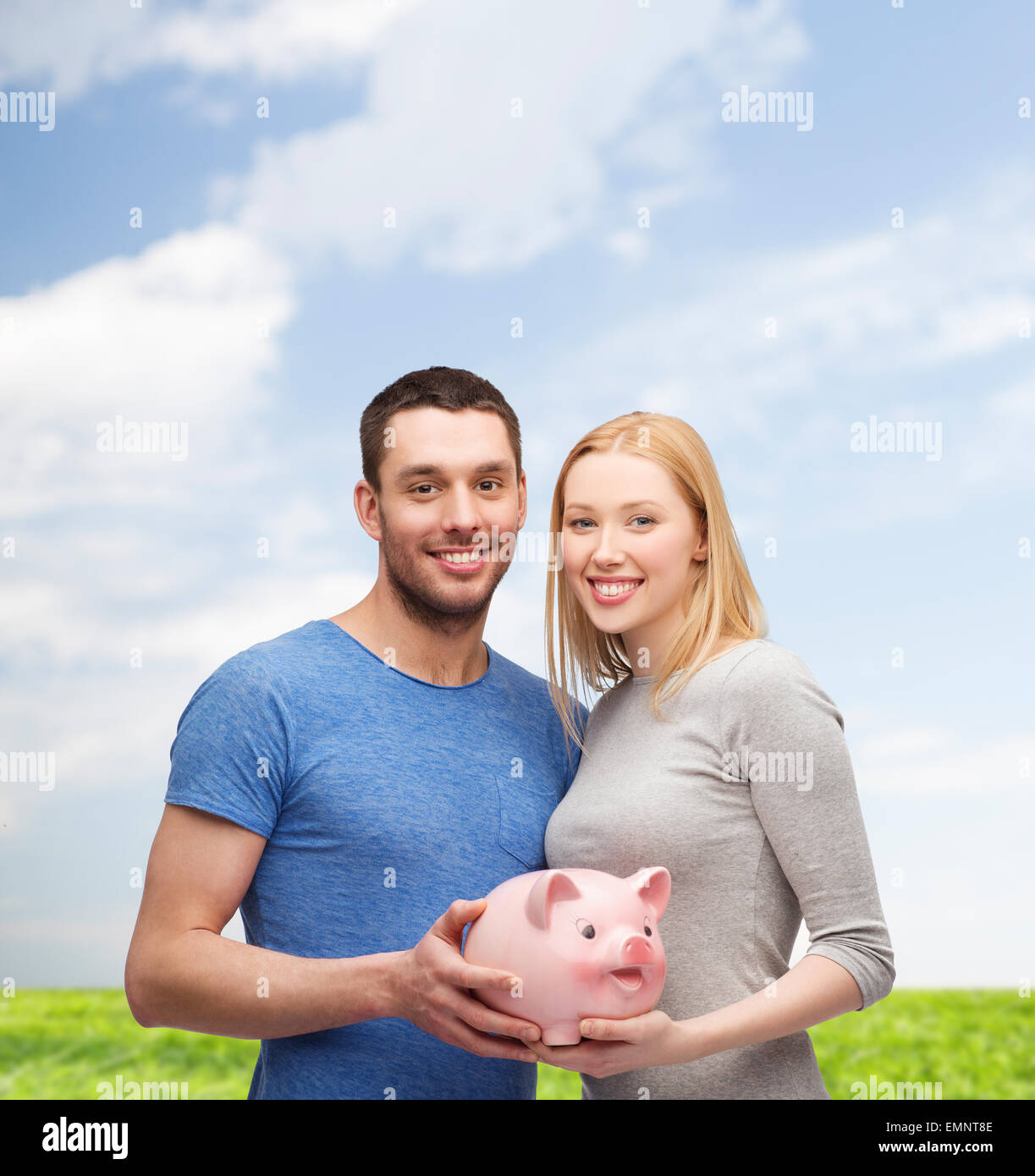 smiling couple holding big piggy bank Stock Photo - Alamy