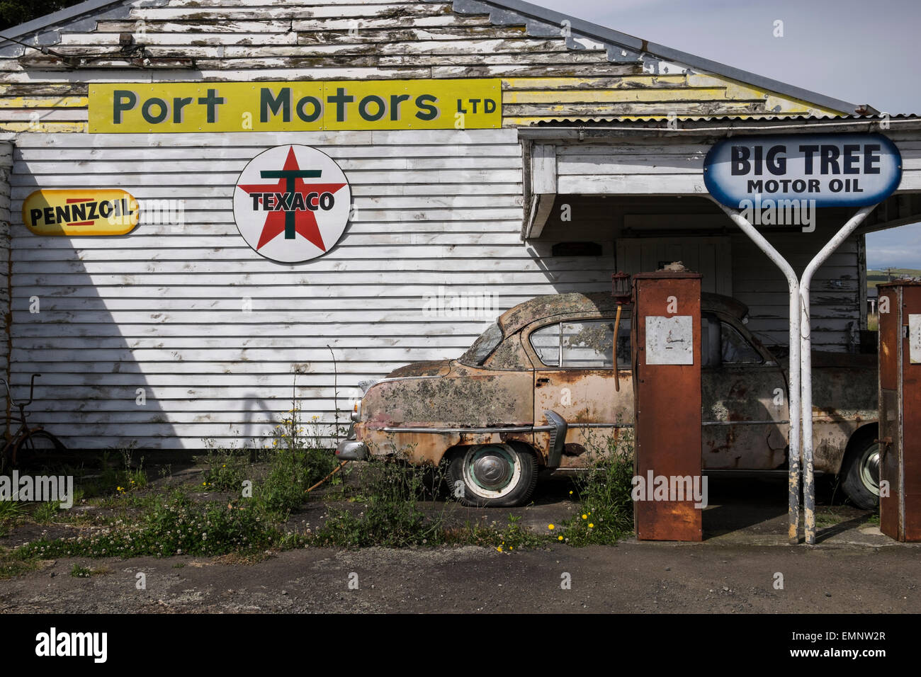 Old abandoned petrol station with a Plymouth Belvedere 1950s car, and two petrol pumps,  rotting on the forecourt. Ormondville, Stock Photo